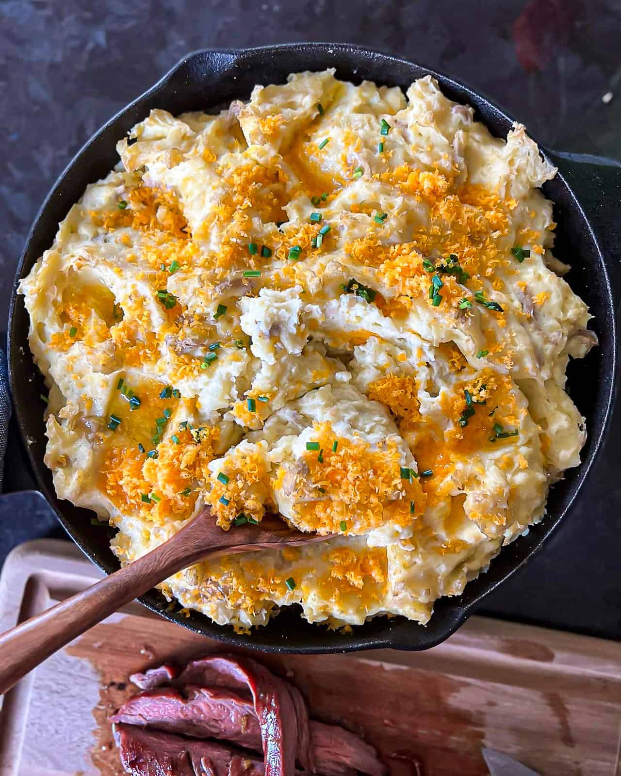 Smoked garlic mashed potatoes with cheddar cheese and chives on top