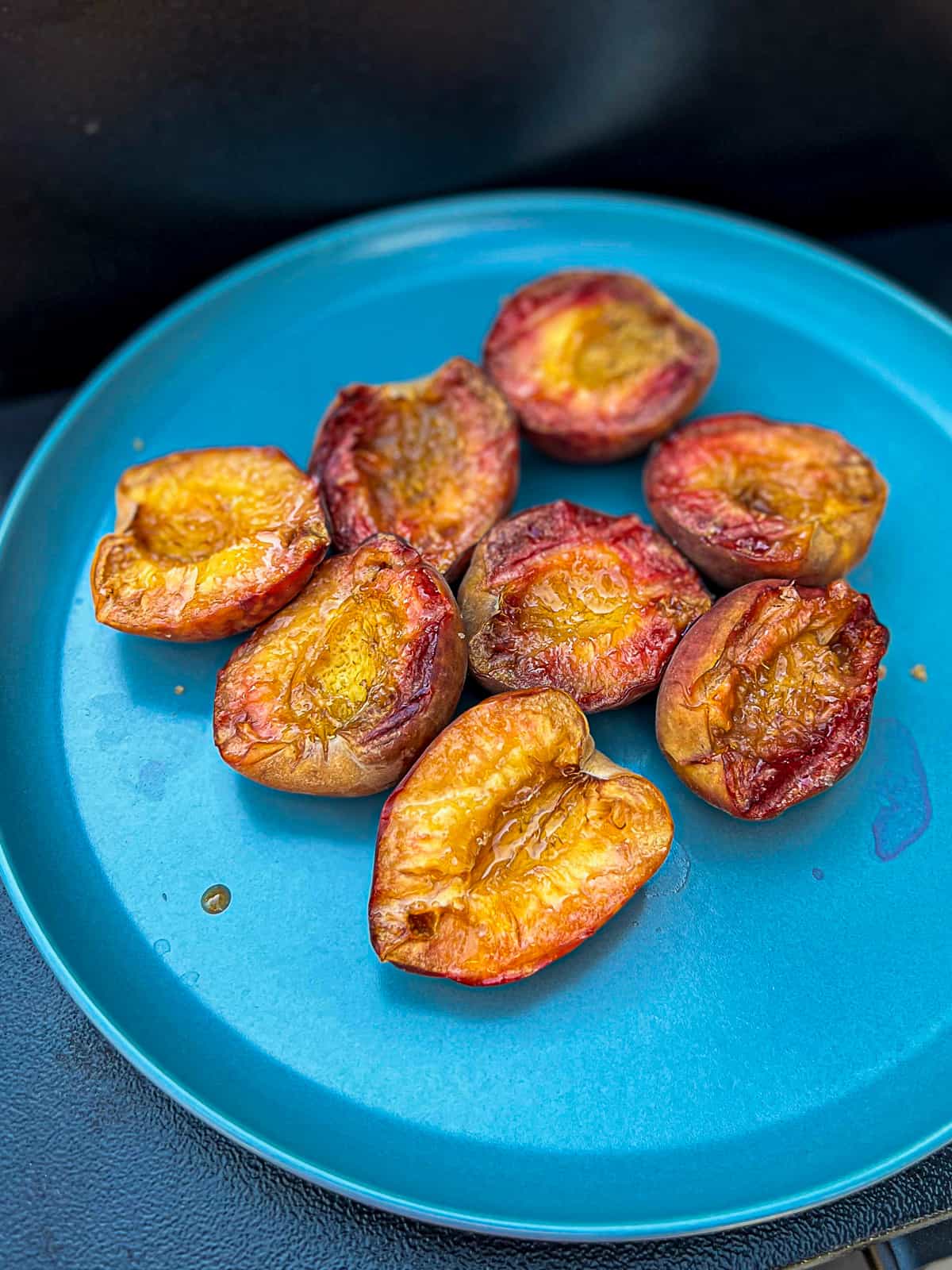 Smoked peach halves on an appetizer plate on the Traeger