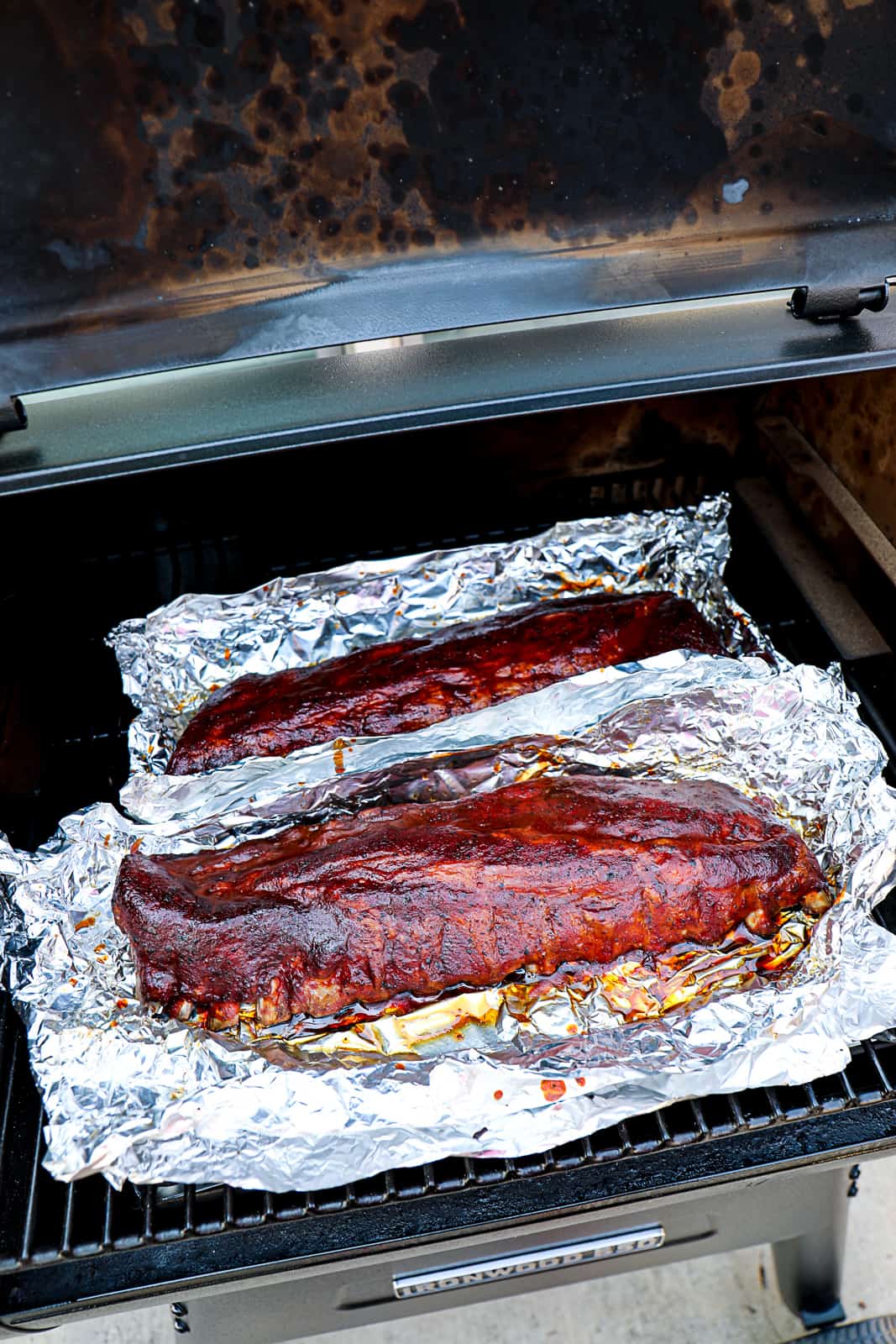 Smoking Traeger 321 baby back ribs with BBQ glaze in open foil packets