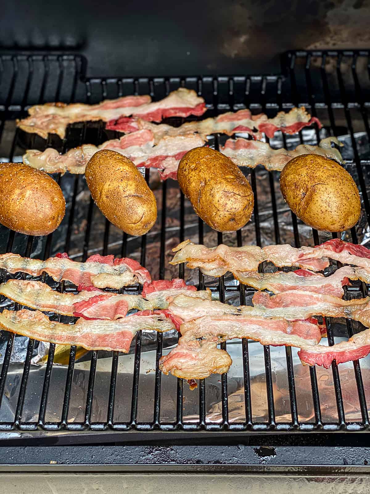 Smoking baked potatoes with bacon on the Traeger pellet grill grates