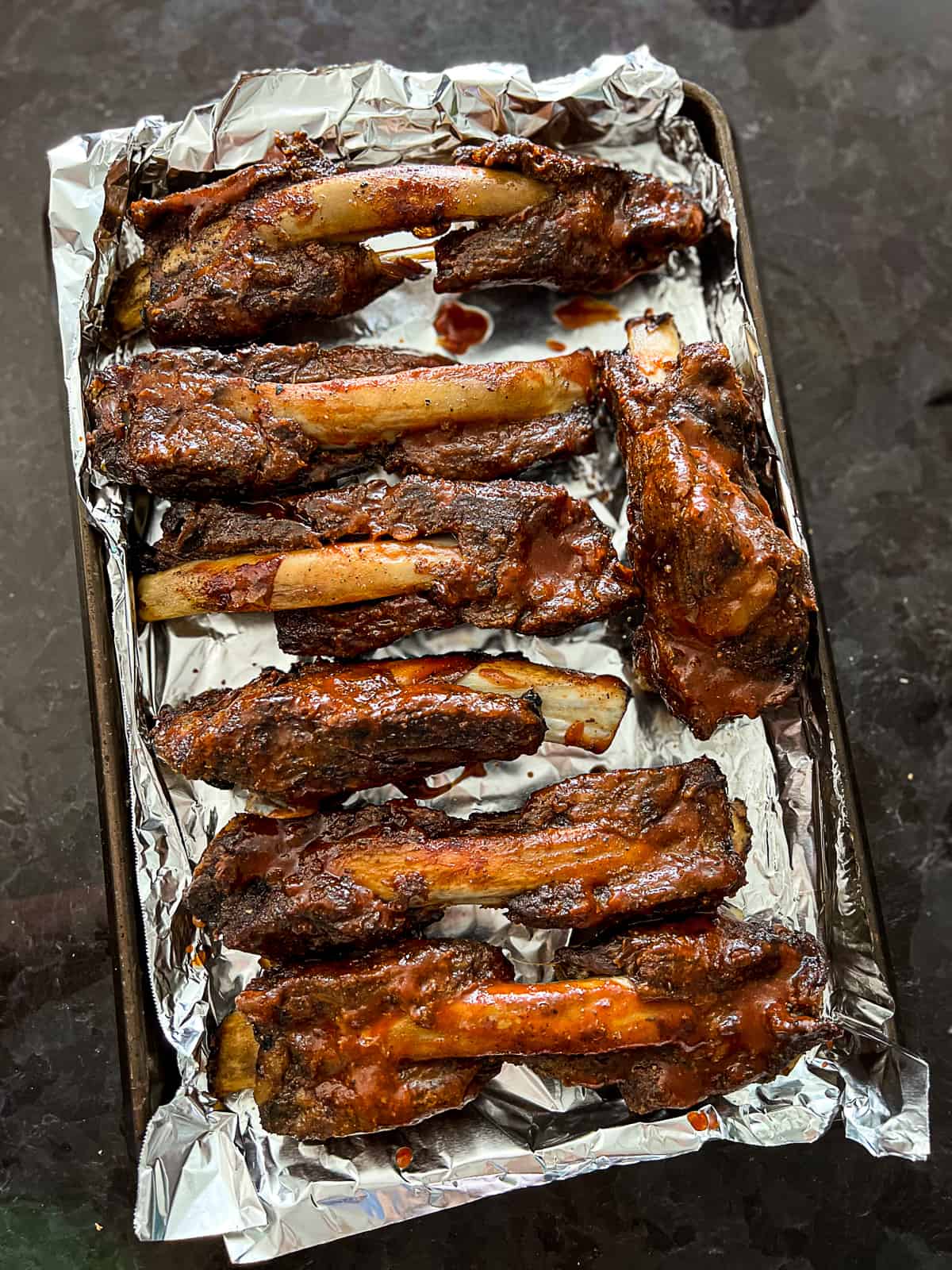 Baking Sheet With Beef Back Ribs cooked with BBQ sauce