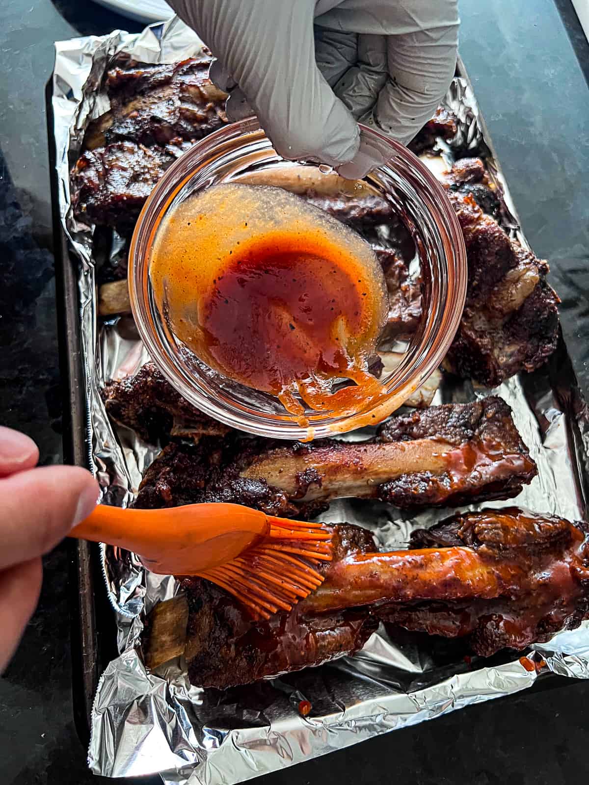 Brushing BBQ sauce on baked Beef Back Ribs