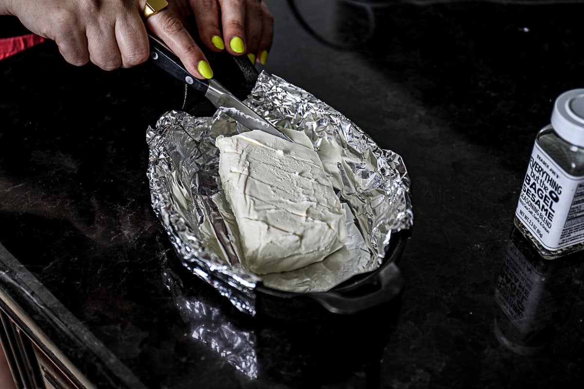 Cutting top of cream cheese with knife to score it for smoking on the Traeger pellet grill