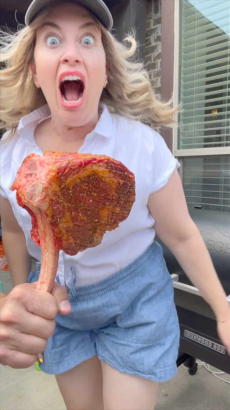Jenna Smoked Food Blogger Biting A Tomahawk Steak By The Traeger Pellet Grills Smoker