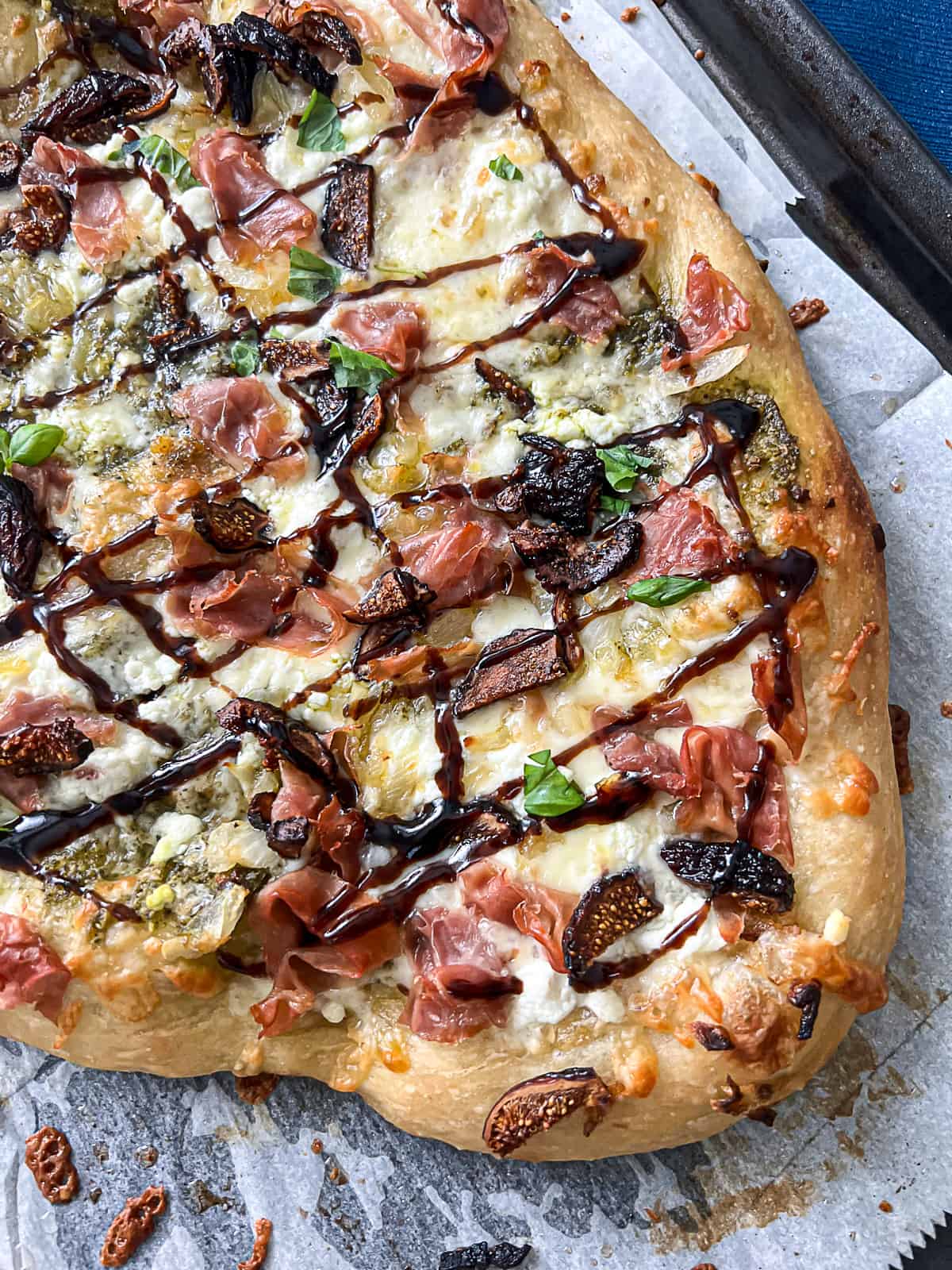 Balsamic glaze topping on pizza with figs and prosciutto and goat cheese