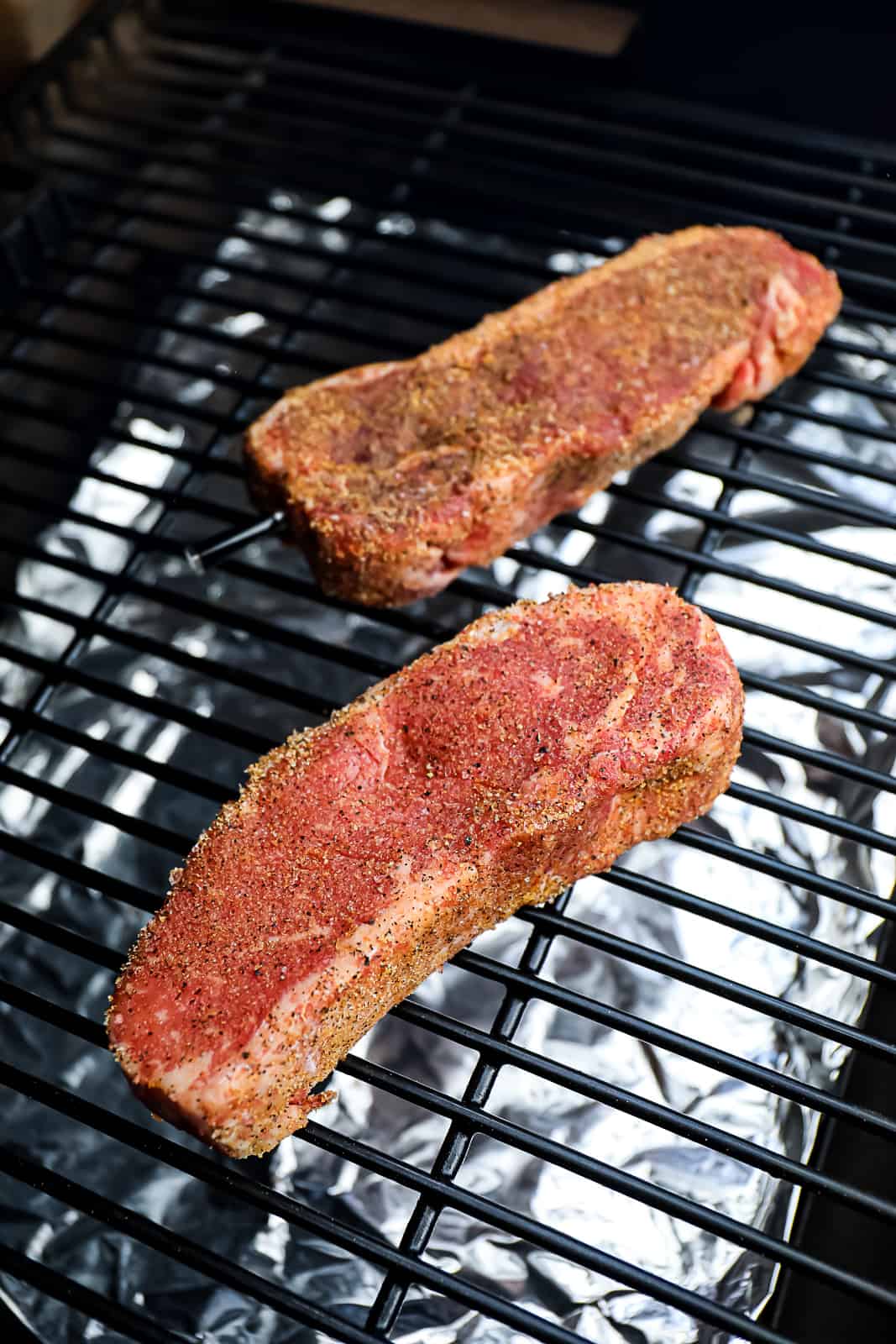 Boneless NY strip steaks smoking on Traeger Pellet Smoker