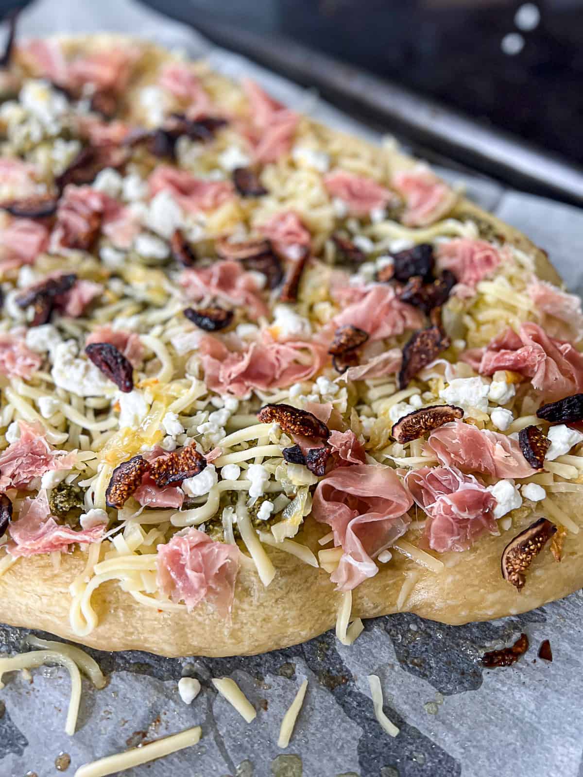 Closeup of pizza recipe with prosciutto and figs on top