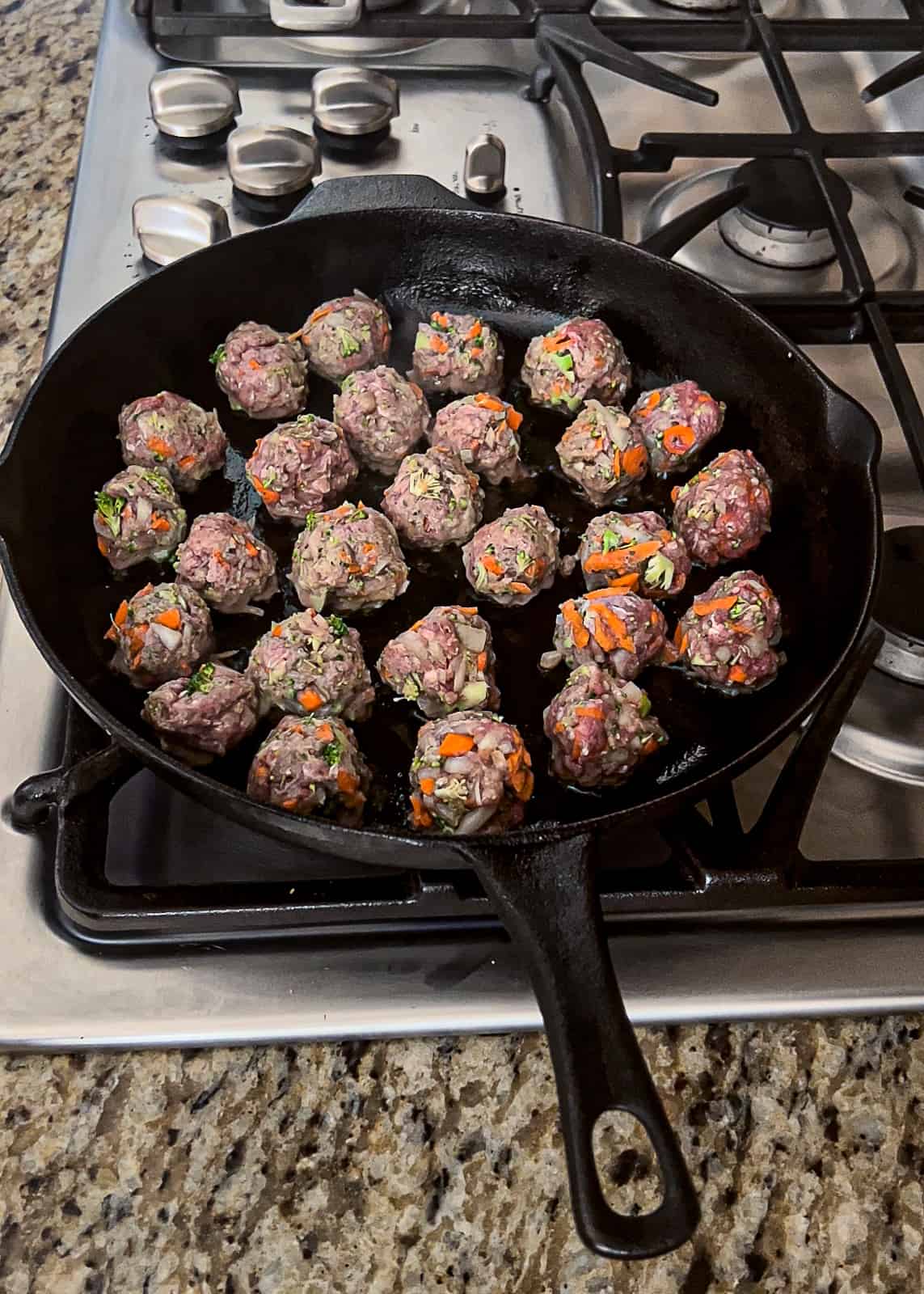 Browning vegetable and ground beef meatballs on the stove