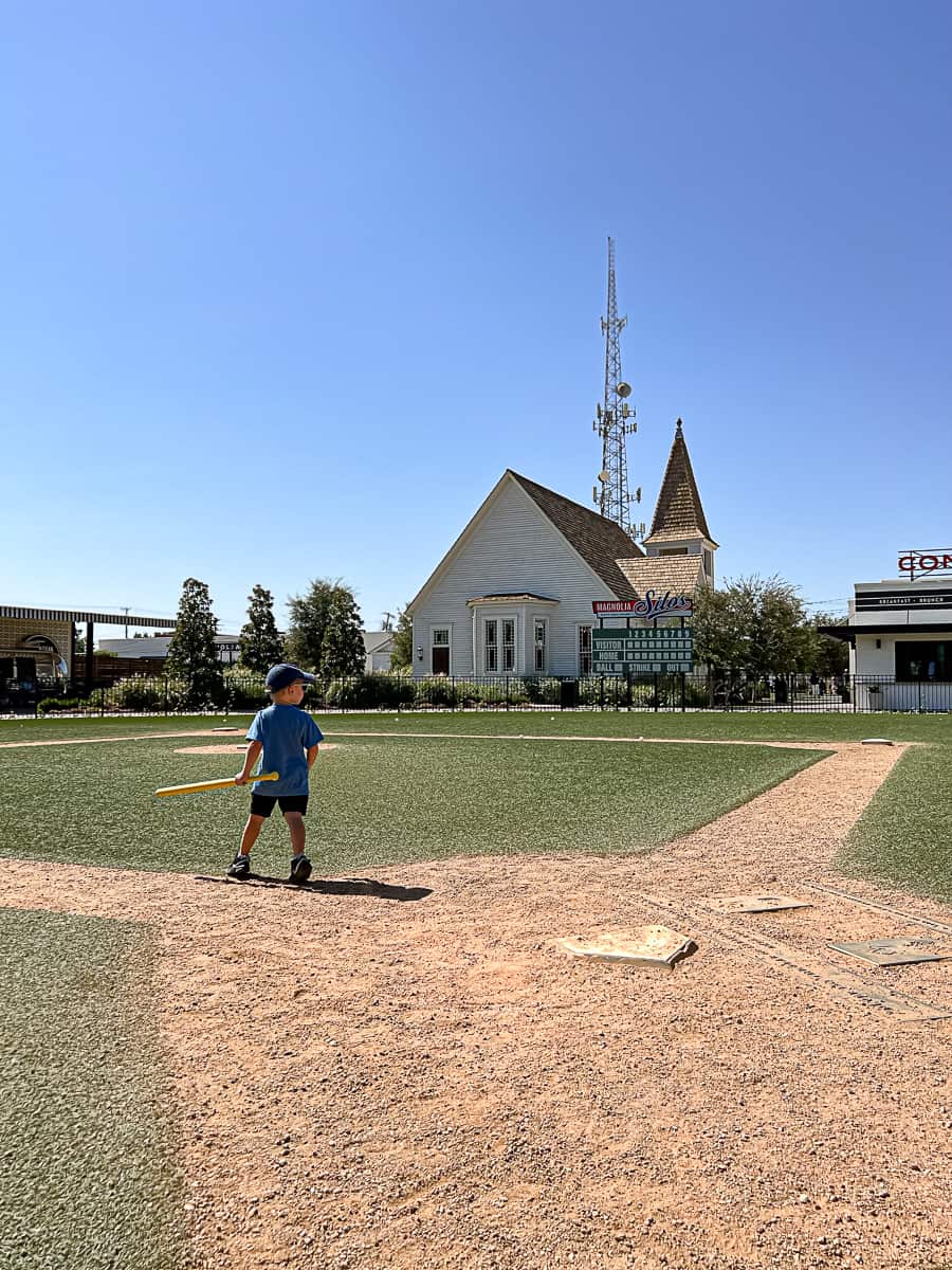 Kid playing Wiffle Ball at the Silos baseball field in Waco Texas
