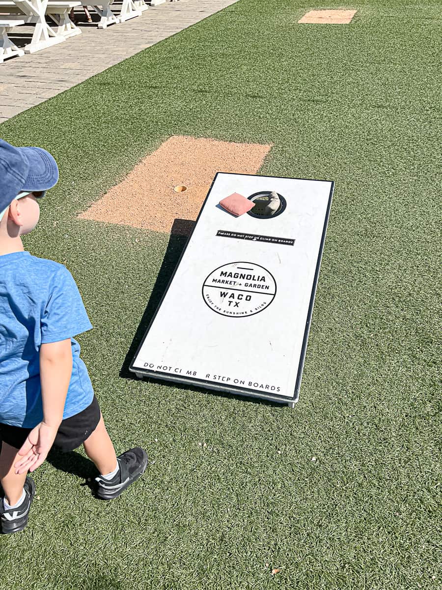 Kid playing cornhole at Magnolia Market And Garden at the Silos in Waco Texas