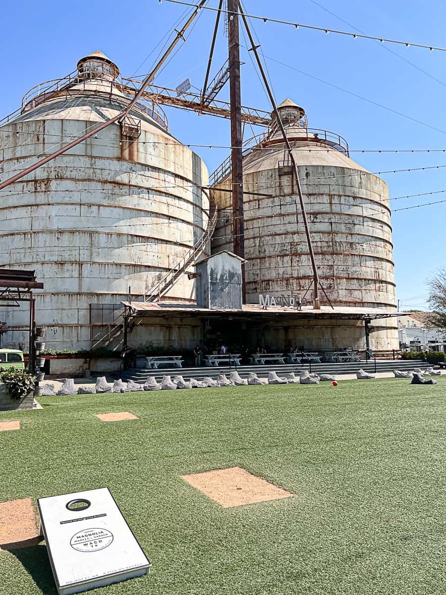 Magnolia Silos with the old logo sign in Waco Texas with the Great Lawn and a cornhole field for kids