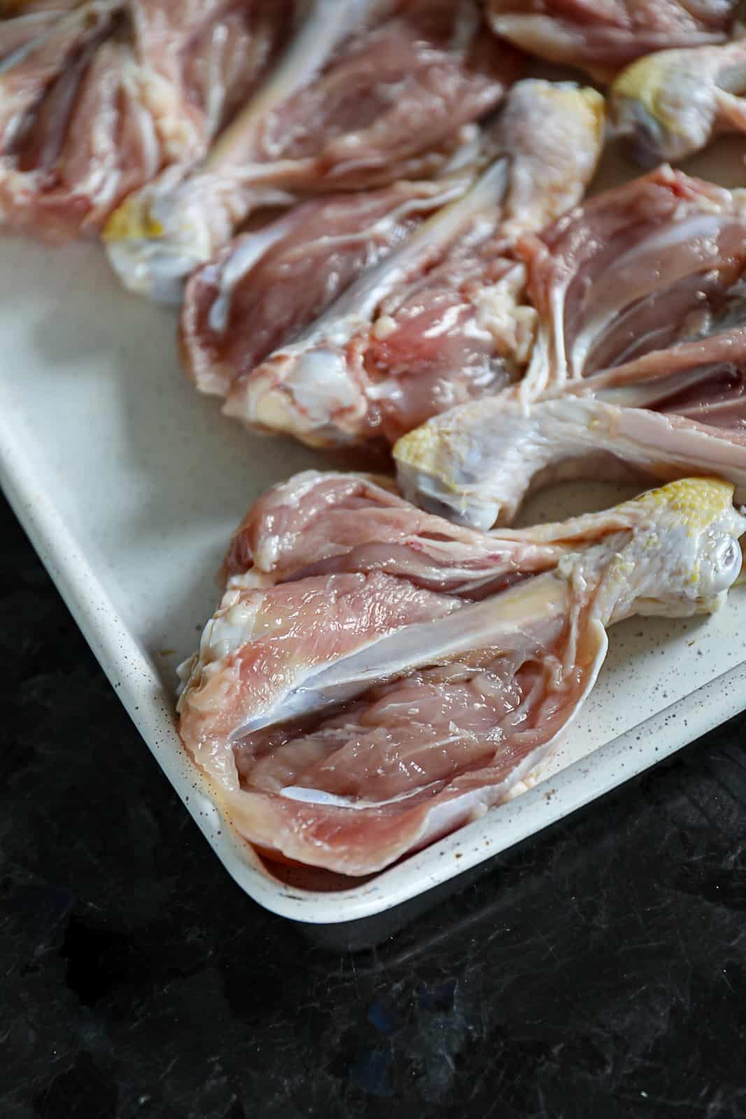 Sheet Pan with butterfly chicken legs cut in half for smoking Sip Bite Go