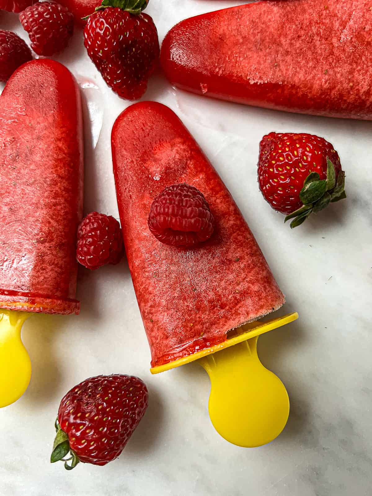 Closeup of homemade popsicles with strawberries and raspberries on Ikea Molds 