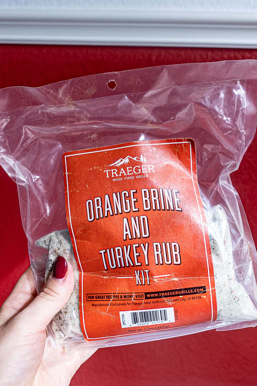 Holding a seasoning bag of Traeger orange brine and turkey rub kit from Amazon