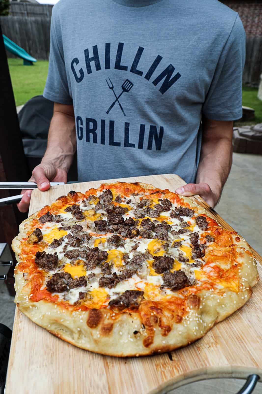 Outdoor grilling cheeseburger pizza