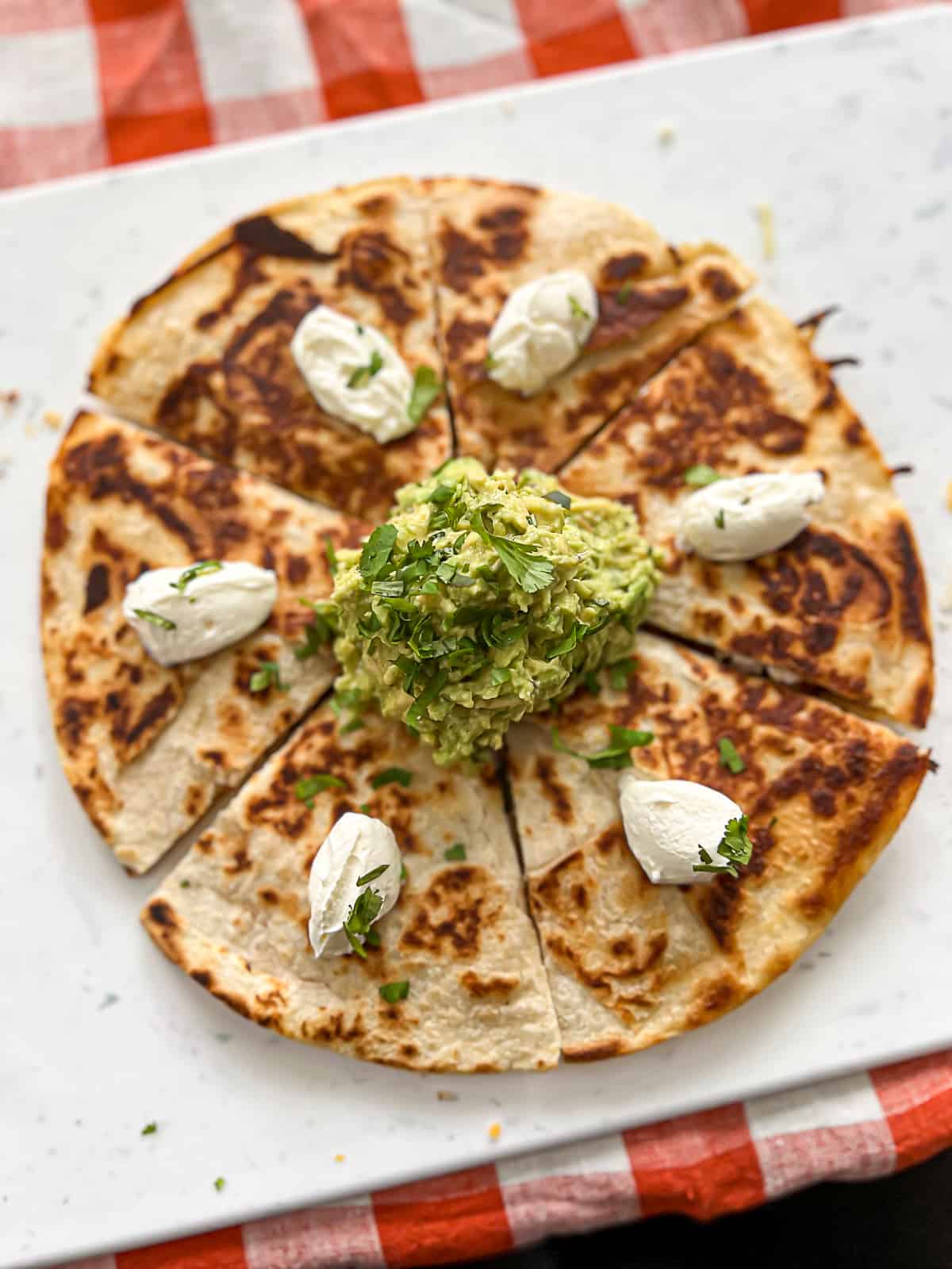 Flattop Griddle Quesadilla Recipe with guacamole and sour cream on a serving tray
