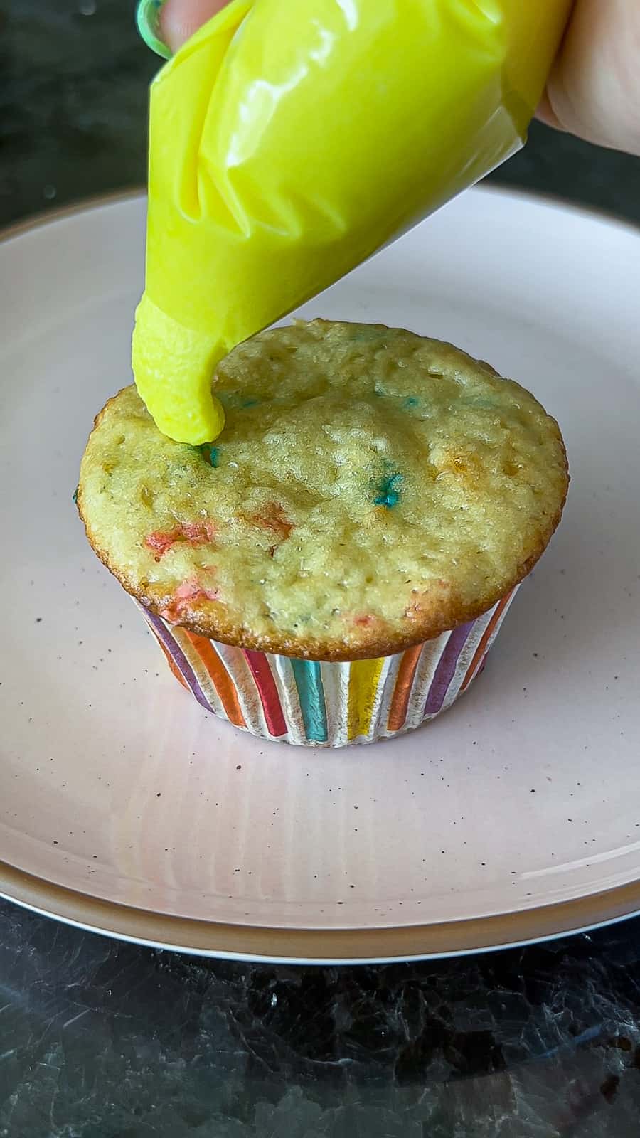 Adding frosting to Funfetti Cupcakes
