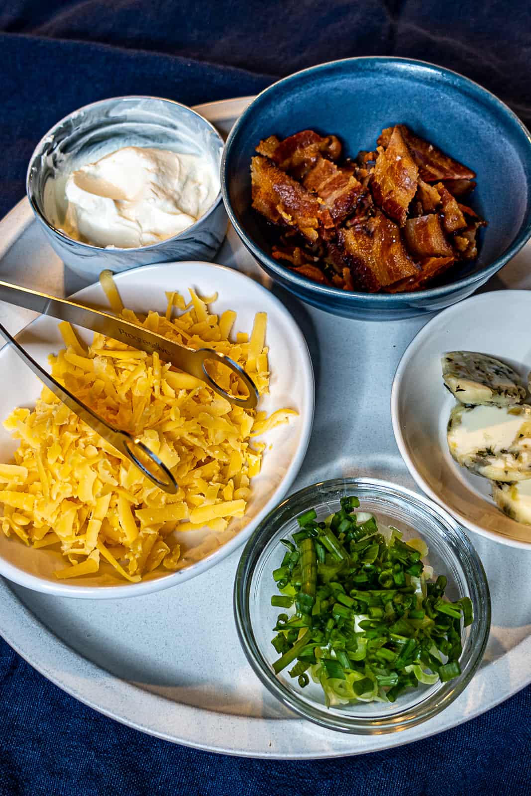 Baked Potatoes Toppings Board with Cheddar Cheese and Bacon and Chives