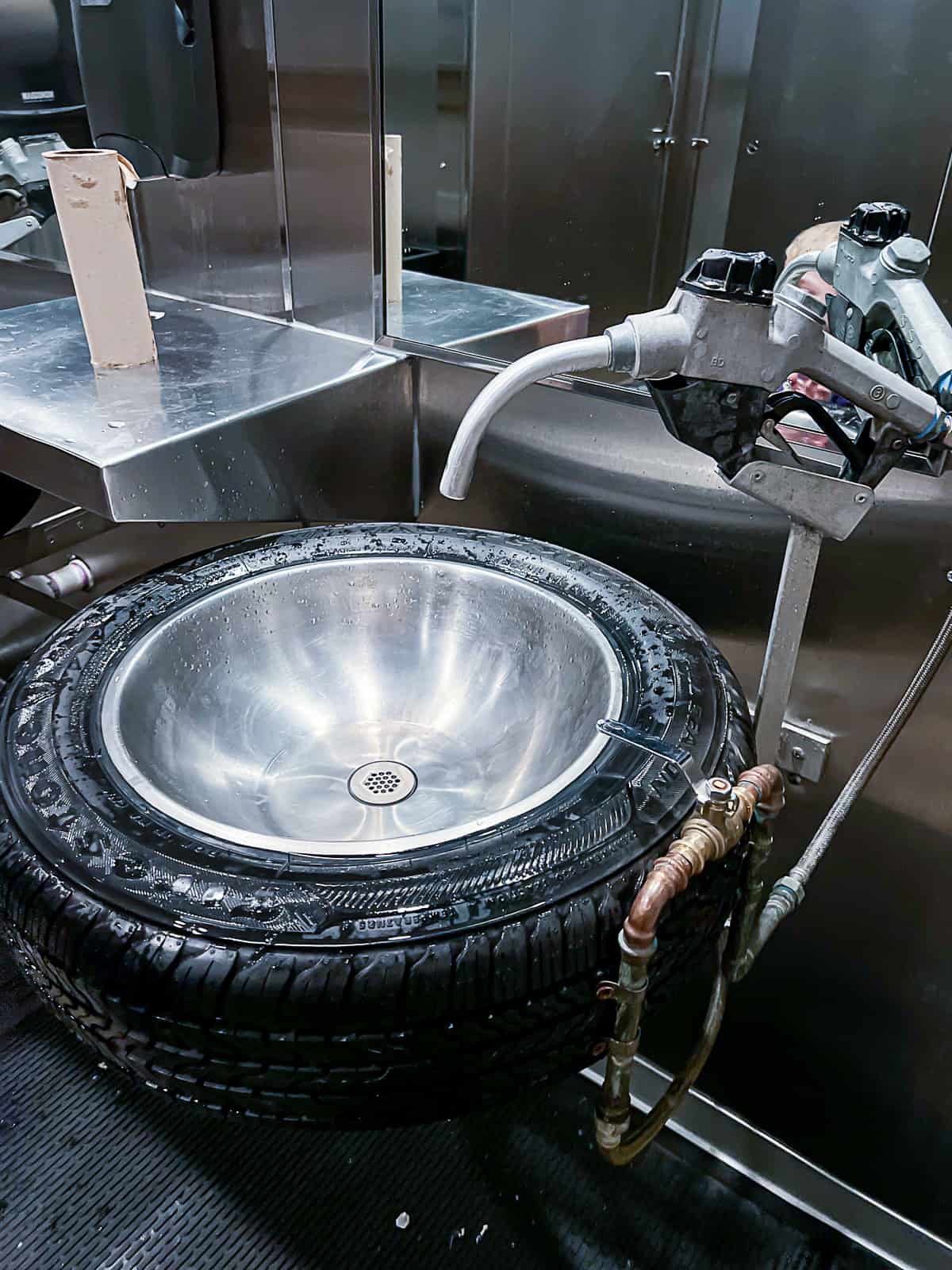 Bathroom sink made out of tires and a gas pump at Fords Garage Restaurant in Plano Texas