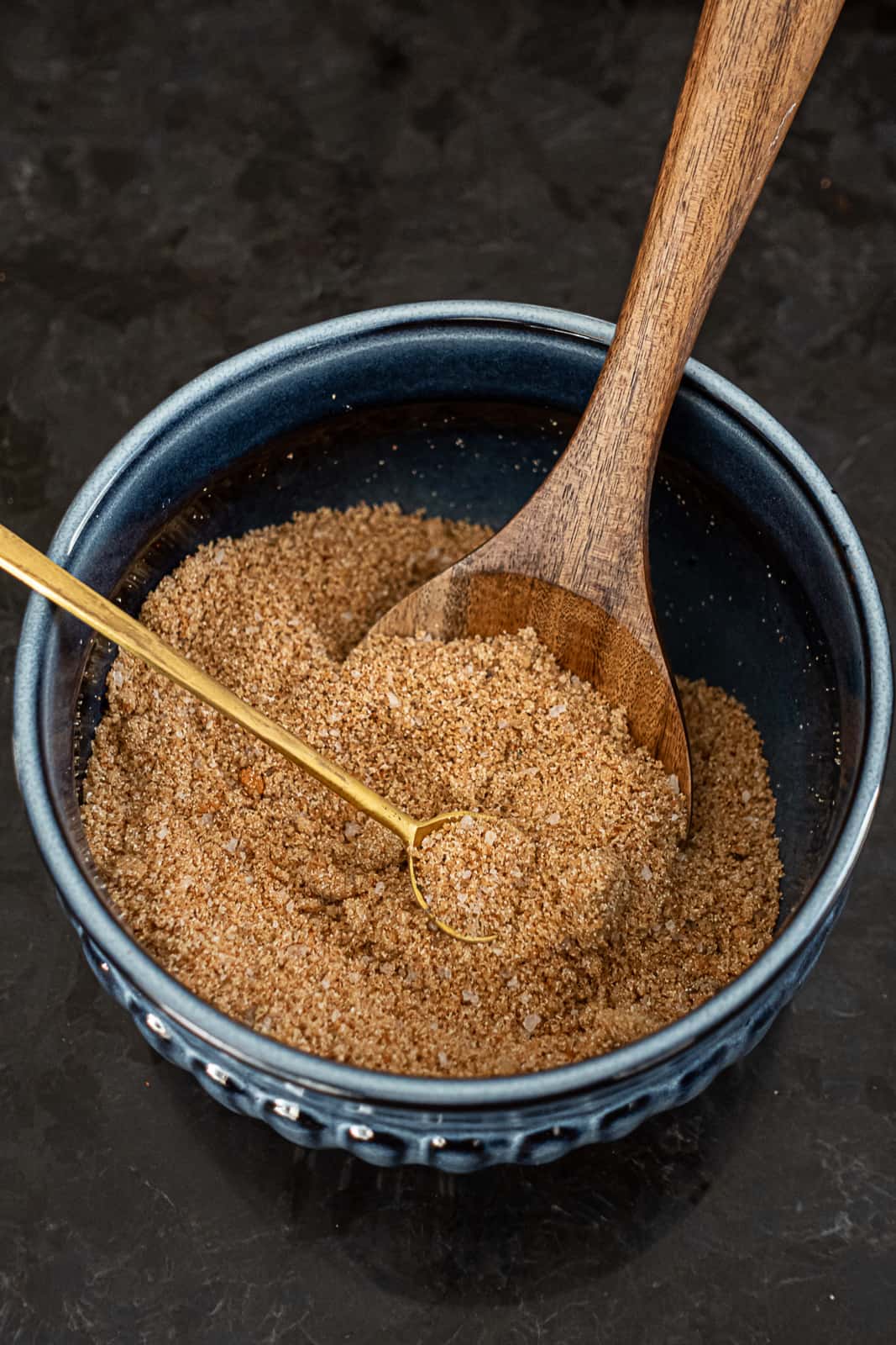 Homemade pork rib spice blend in a bowl with mixing spoons
