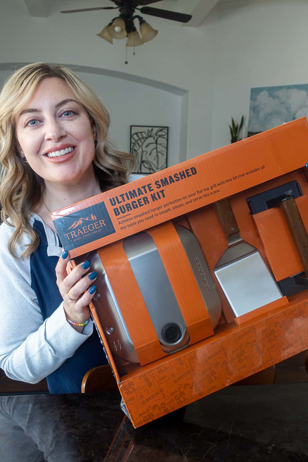 Jenna Passaro holding Traeger Flatrock Ultimate Smash Burger Kit in Box