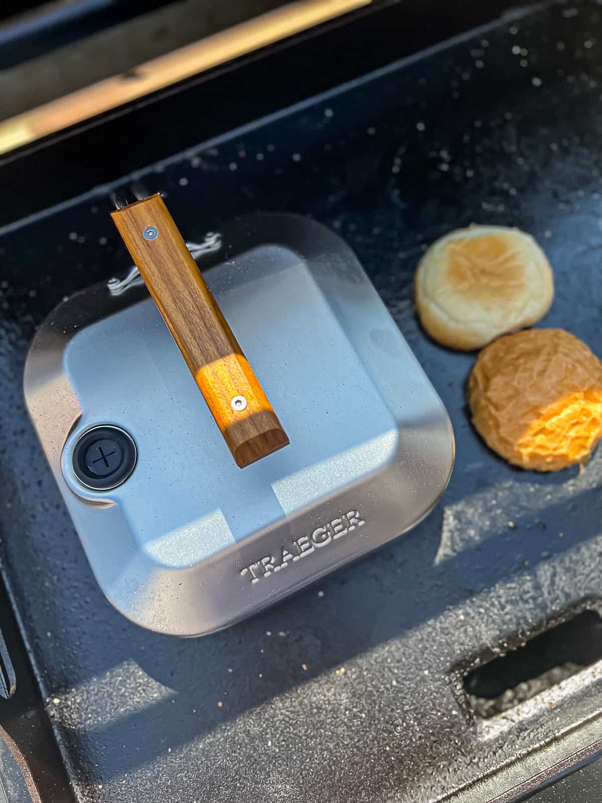 Traeger Flatrock Griddle cooking smashed burgers with a steam dome tool