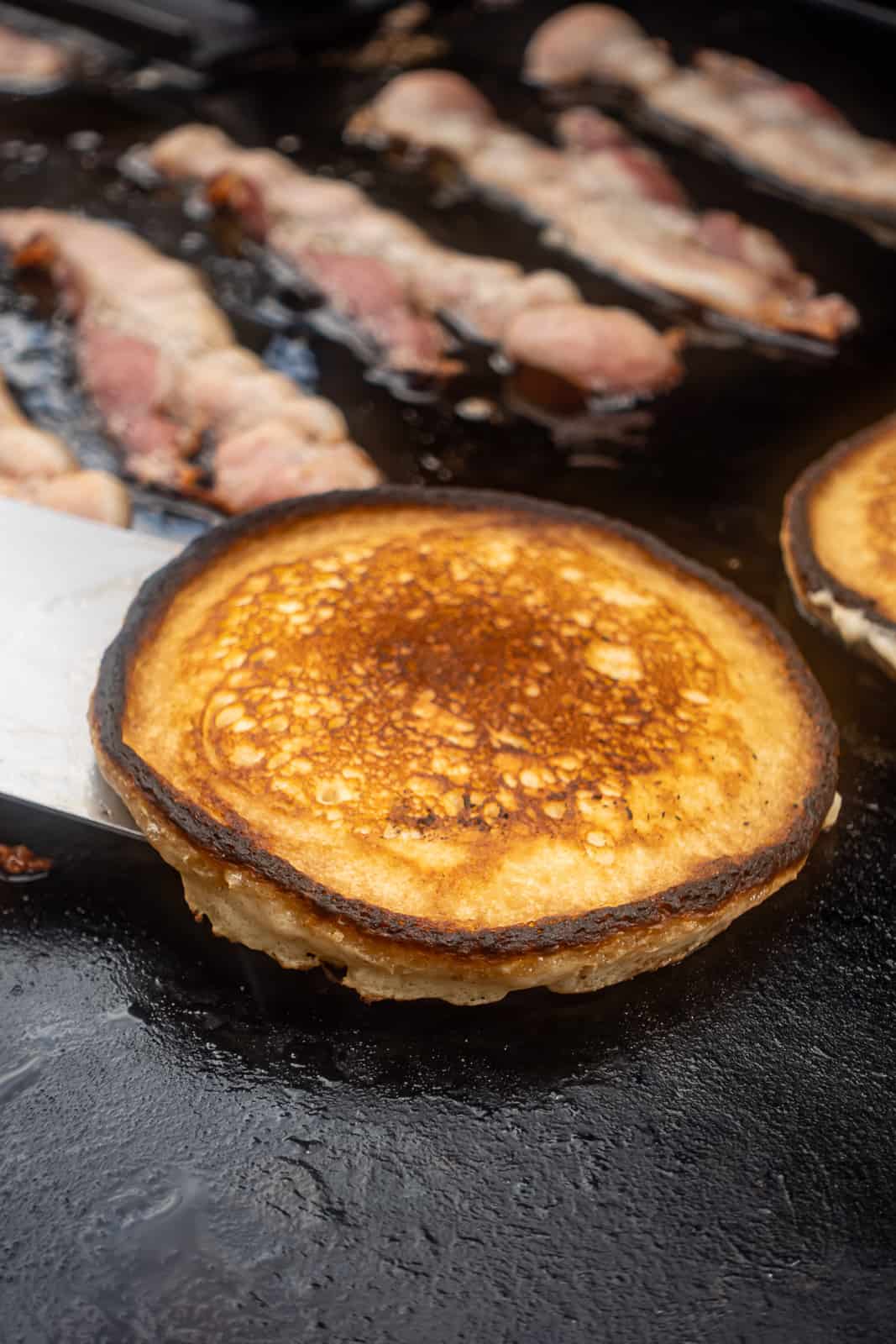 Cooking pancakes on the griddle Flatrock Grill from Traeger with bacon