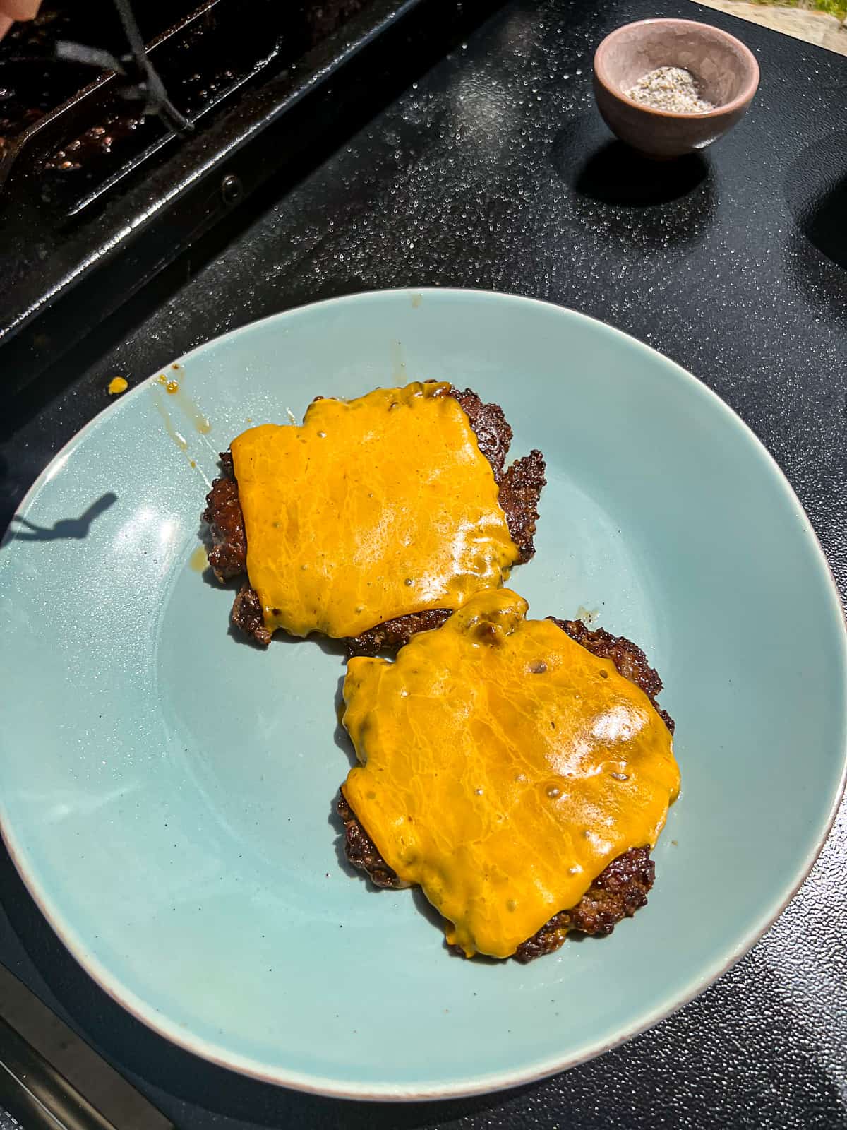 Griddled smashed Cheeseburgers on a plate on the Flatrock Griddle 