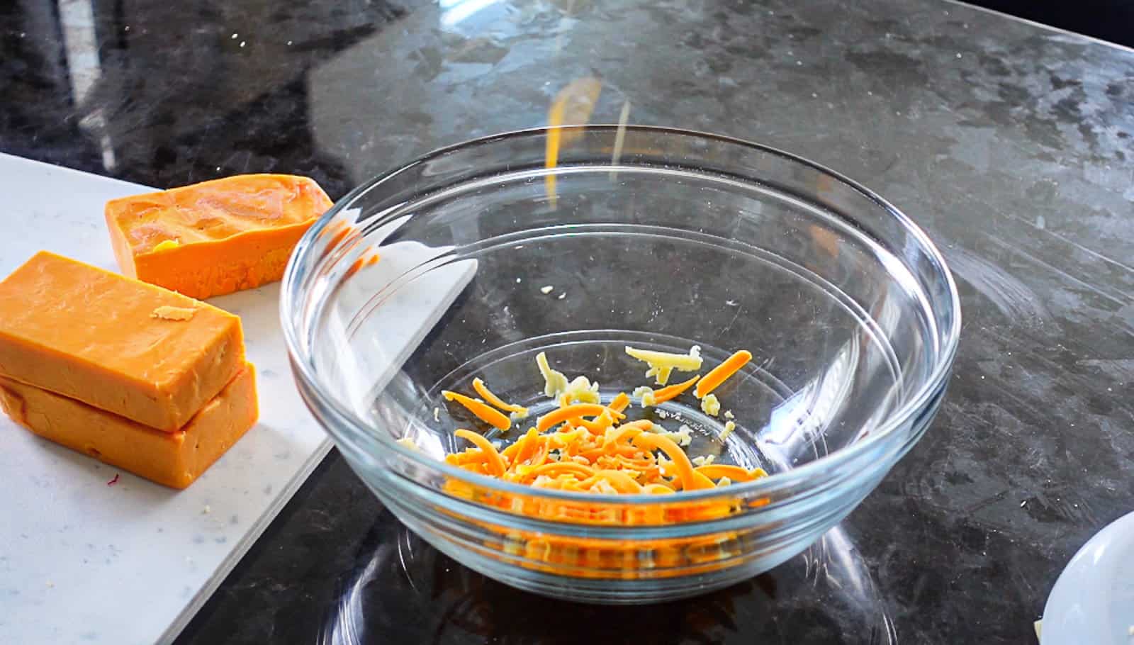 Shredded cheese falling into bowl using the KitchenAid Fresh Prep Slicer Shredder Attachment