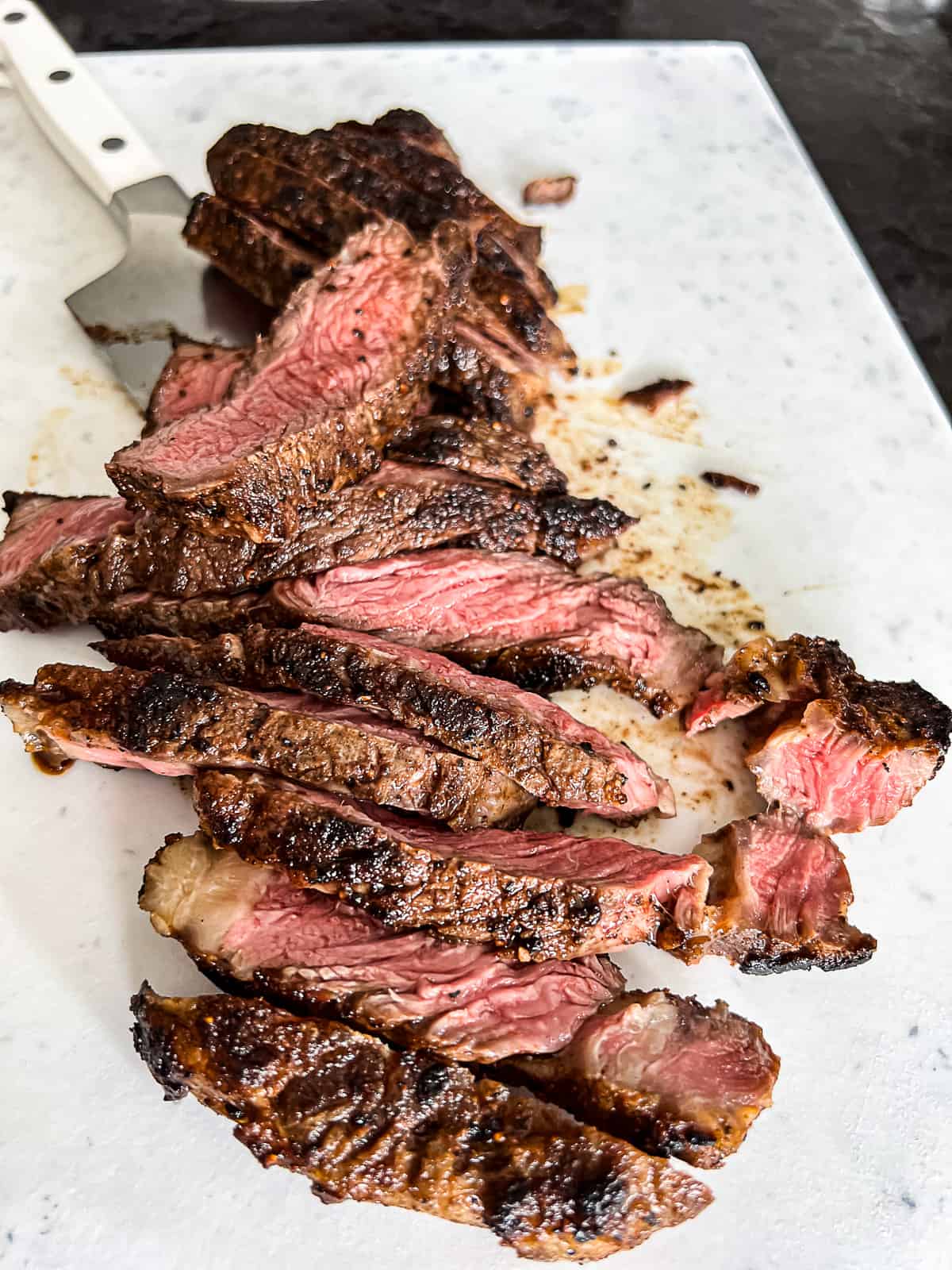 Sliced Griddle Ribeye Steak on a cutting board 