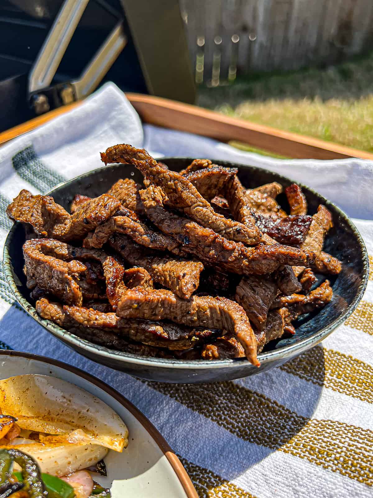 Steak Fajitas Meat next to Traeger Flatrock Griddle Grill 