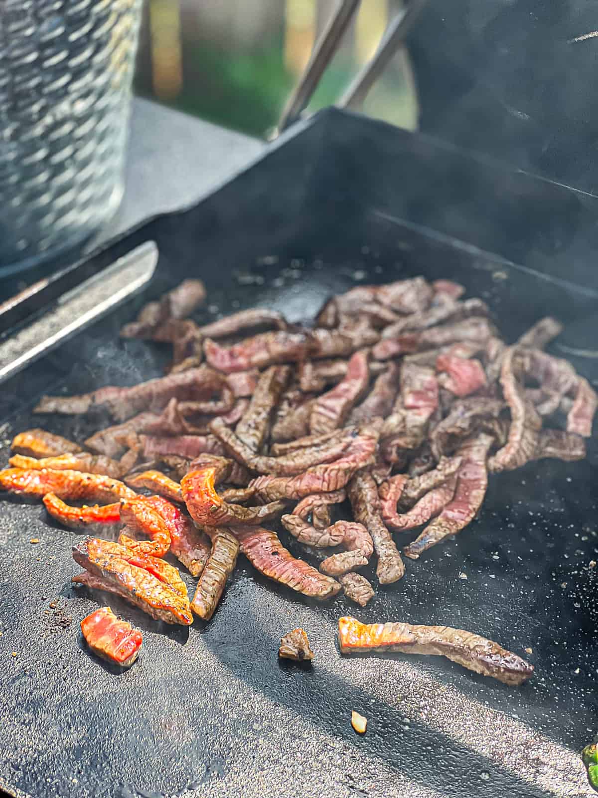 Steak Fajitas Sizzling on the Traeger Flatrock Griddle Cast Iron Cook Top 