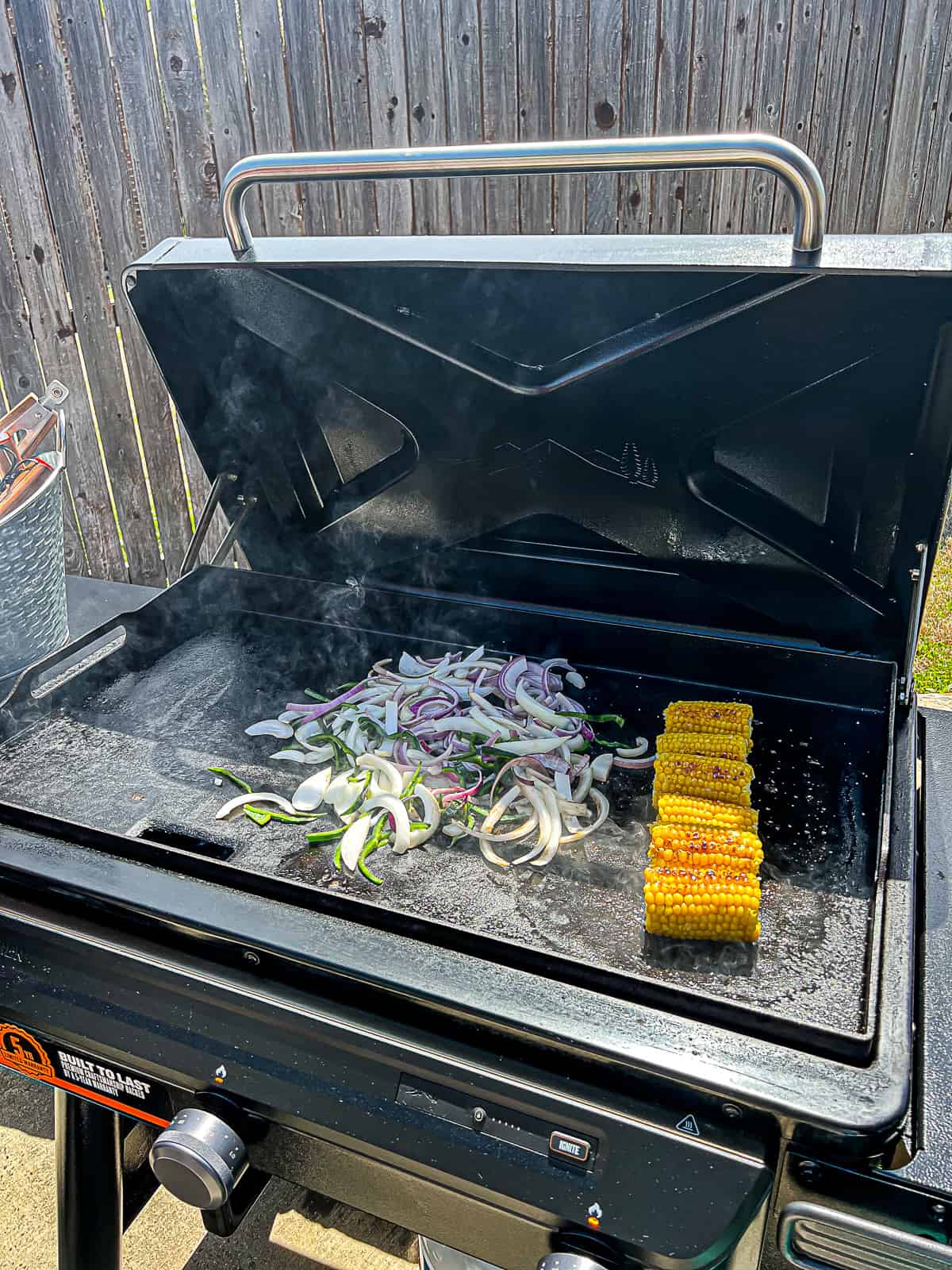 Traeger Griddle Cooking Vegetables for Steak Fajitas with corn on the cob