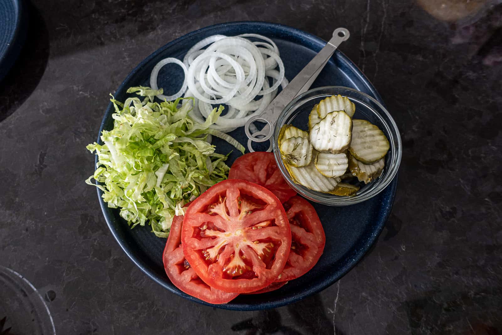 Blackstone Burger Toppings Prepped On A Plate