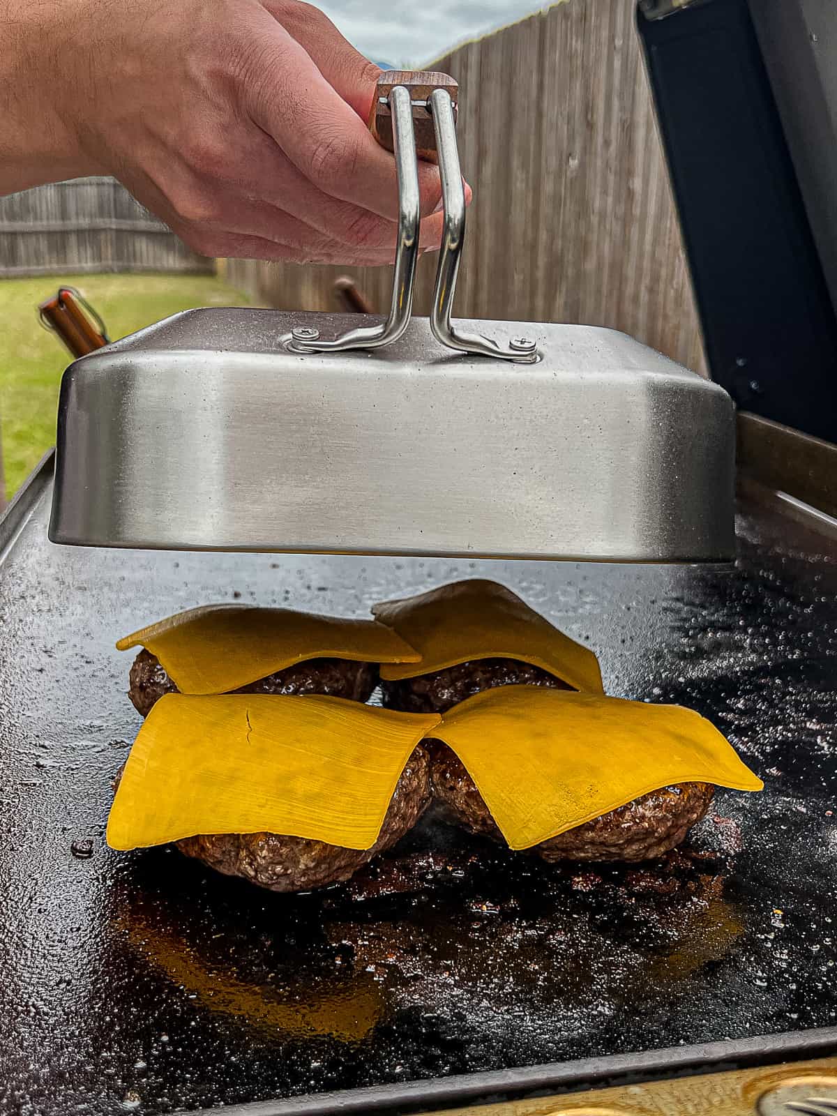 Melting Cheese On Griddle Cooked Blackstone Burgers With A Dome