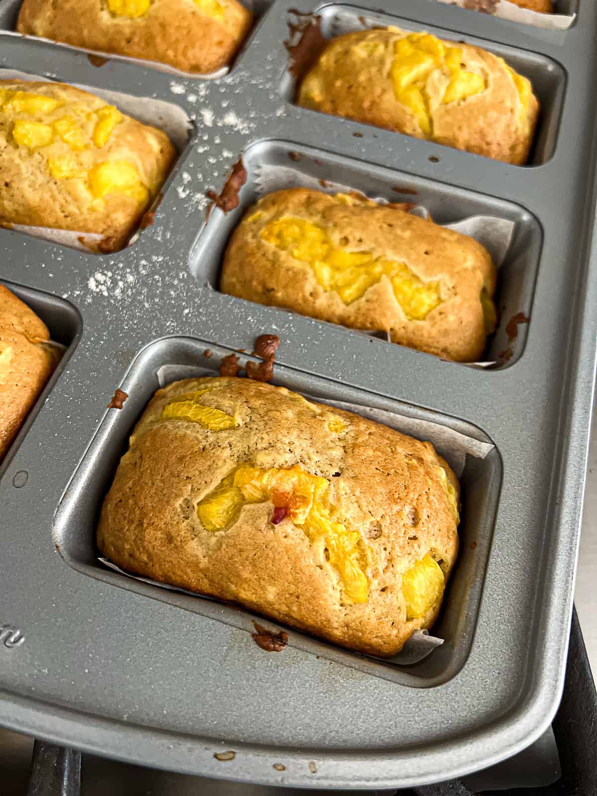 Closeup of Baked Peach Mini Loaves In Pan Cooling