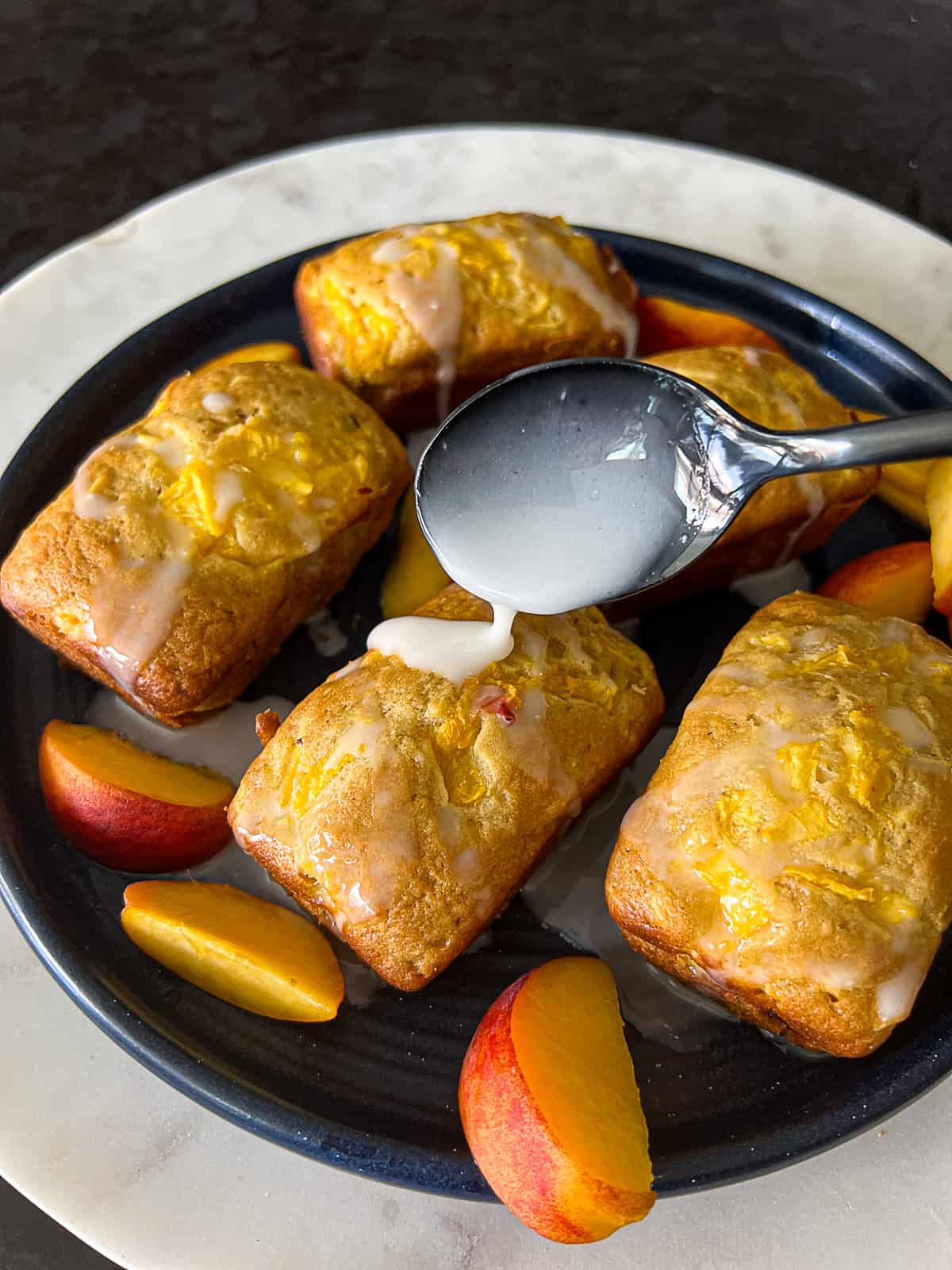 Drizzling Lemon Icing On Peach Mini Loaf Cakes