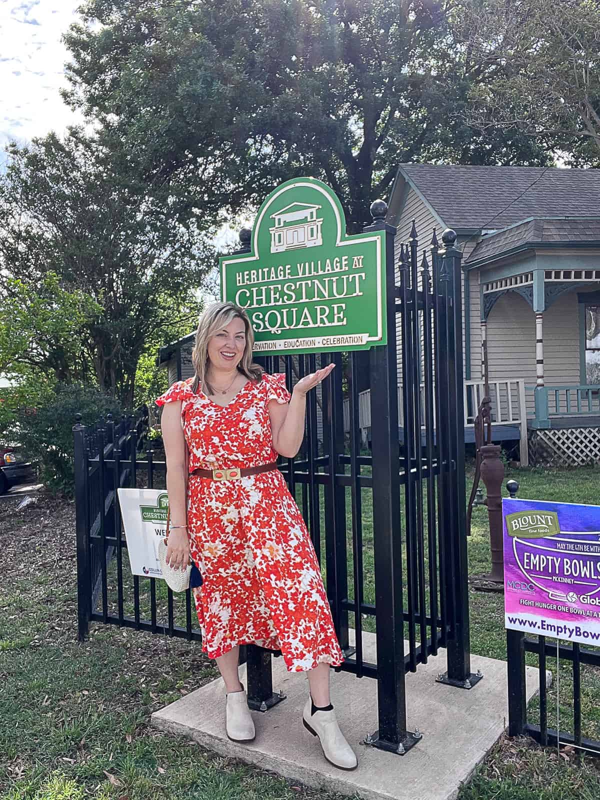 McKinney Travel Blogger outside of Heritage Village at Chestnut Square Sign