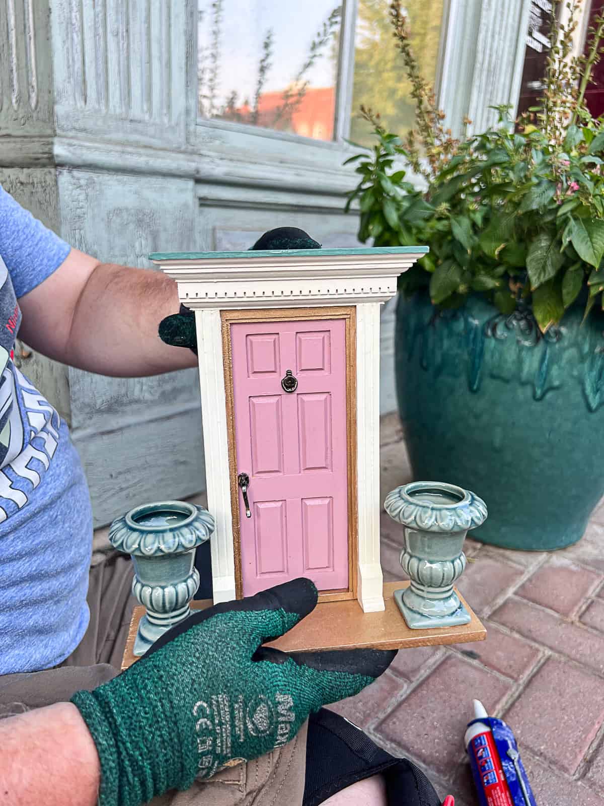 Holding Tiny Door Sculpture Art in front of Downtown McKinney Building Sip Bite Go