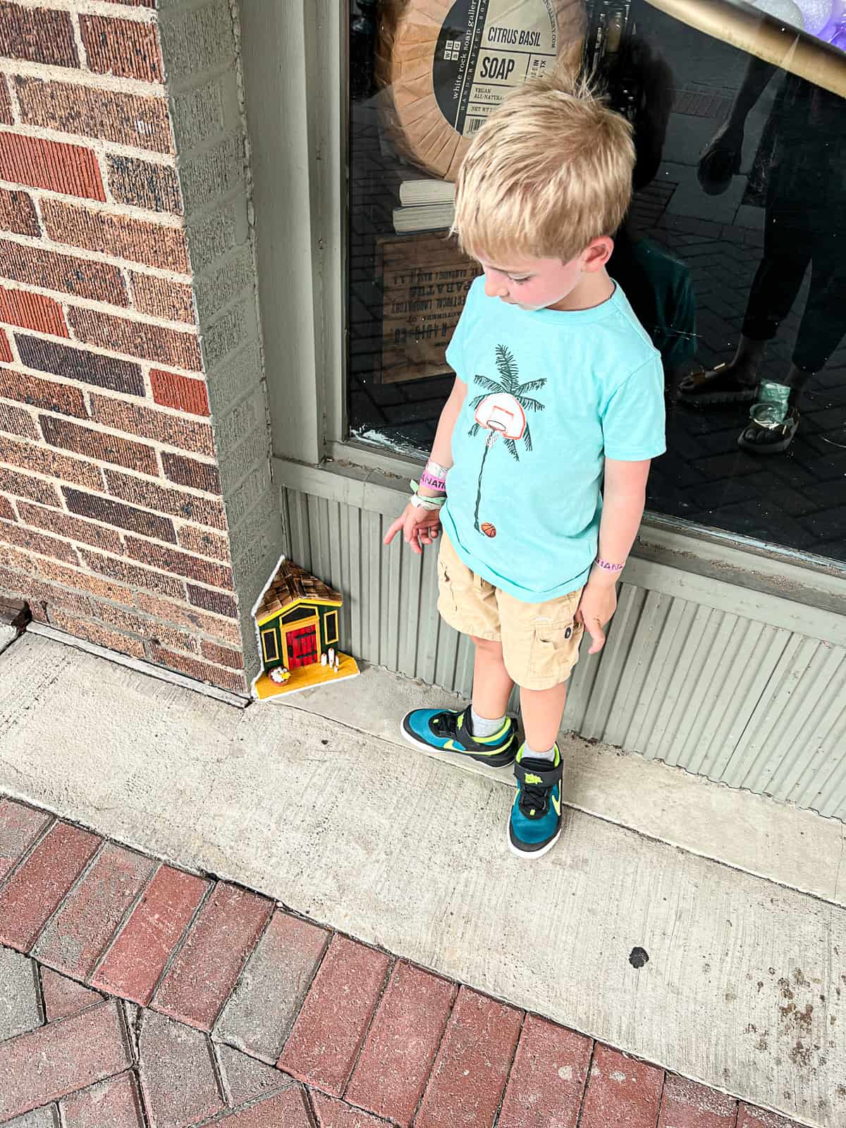 Kid Pointing at Tiny Door Art in McKinney Texas Sip Bite Go