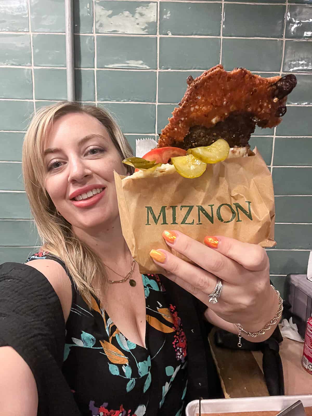 Jenna Passaro Travel Food Blogger holding burger pita from Miznon inside Chelsea Market NYC