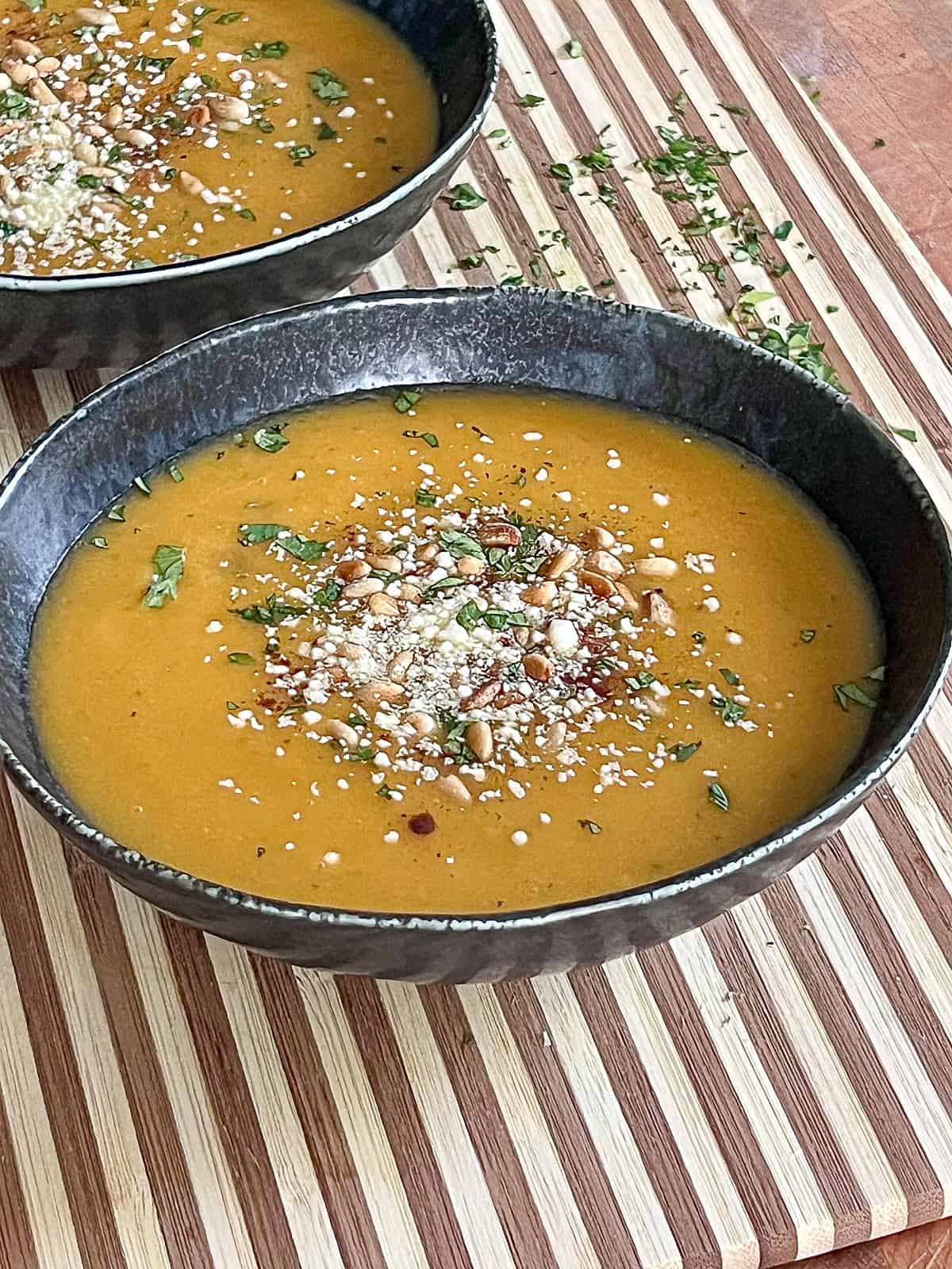 Closeup of herbs and Butternut Squash Soup appetizers on a cutting board