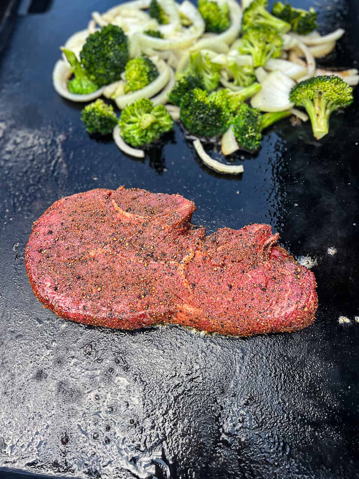 Griddle Cooking Sirloin Steak on Traeger Flatrock with broccoli and onions