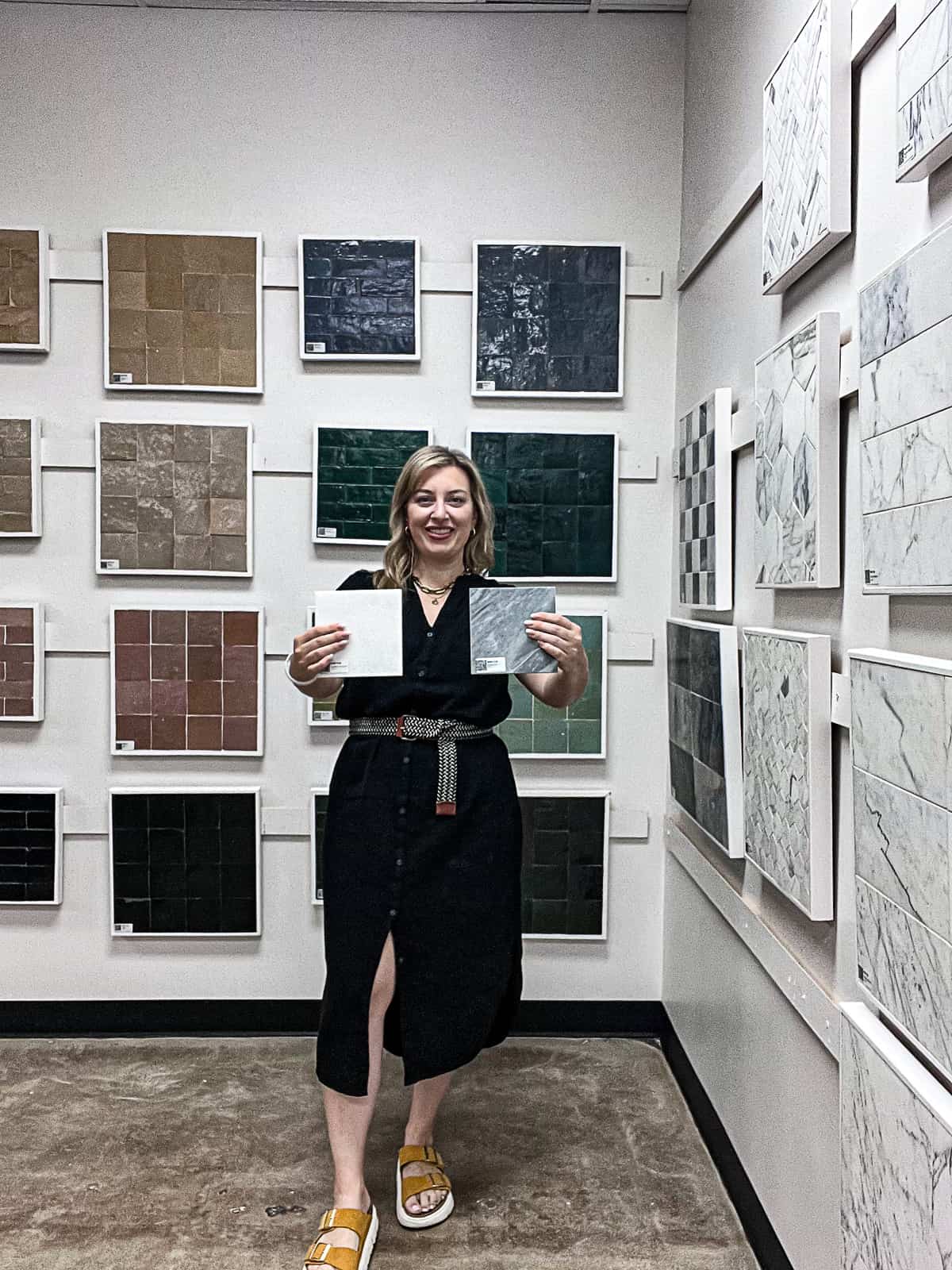 Jenna Passaro Home Interior Style Blogger holding marble flooring at Riad Tile Showroom in Dallas Texas