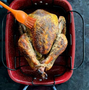 Basting turkey with butter in a roasting pan