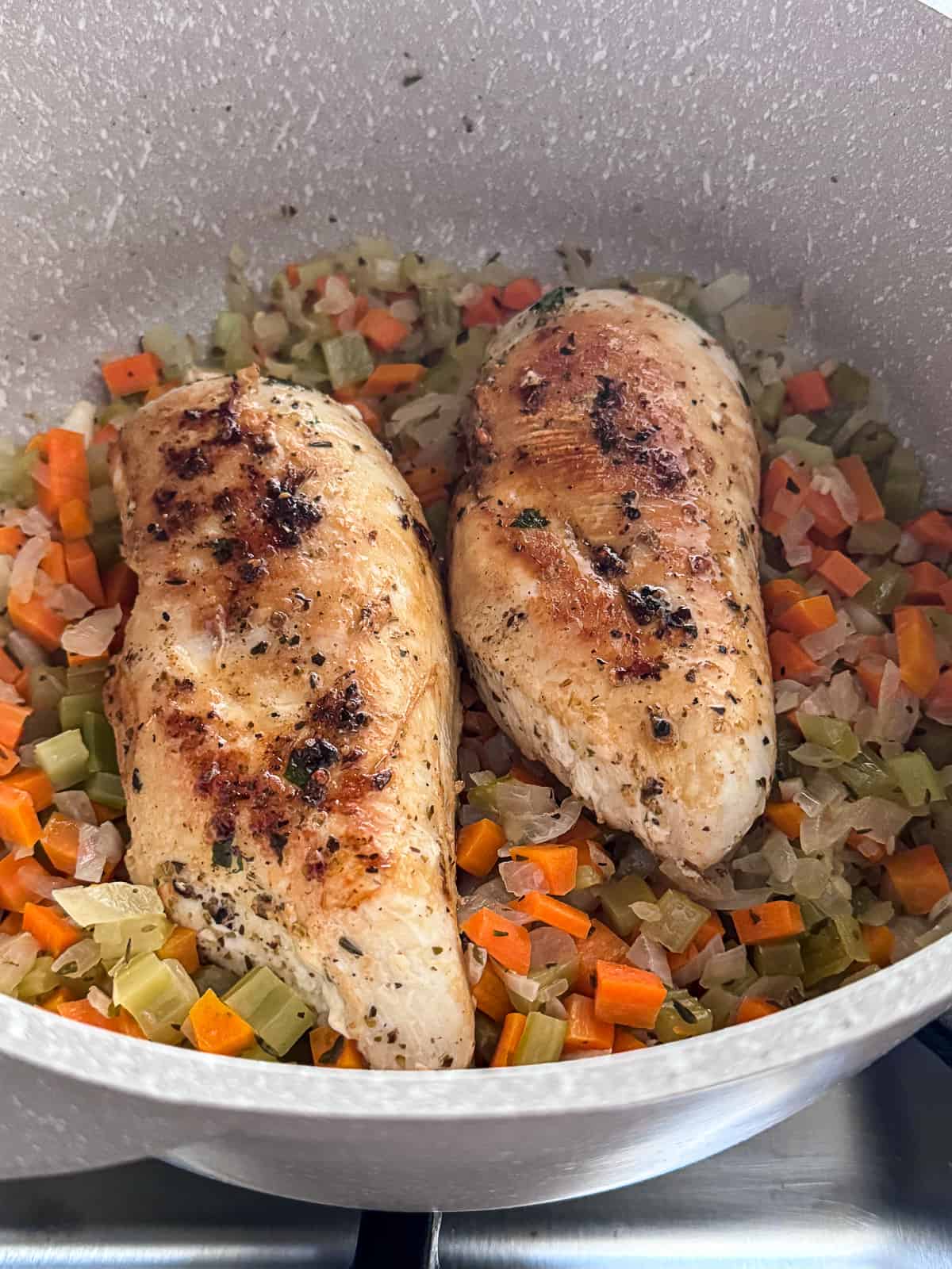 Cooking chicken with vegetables for soup