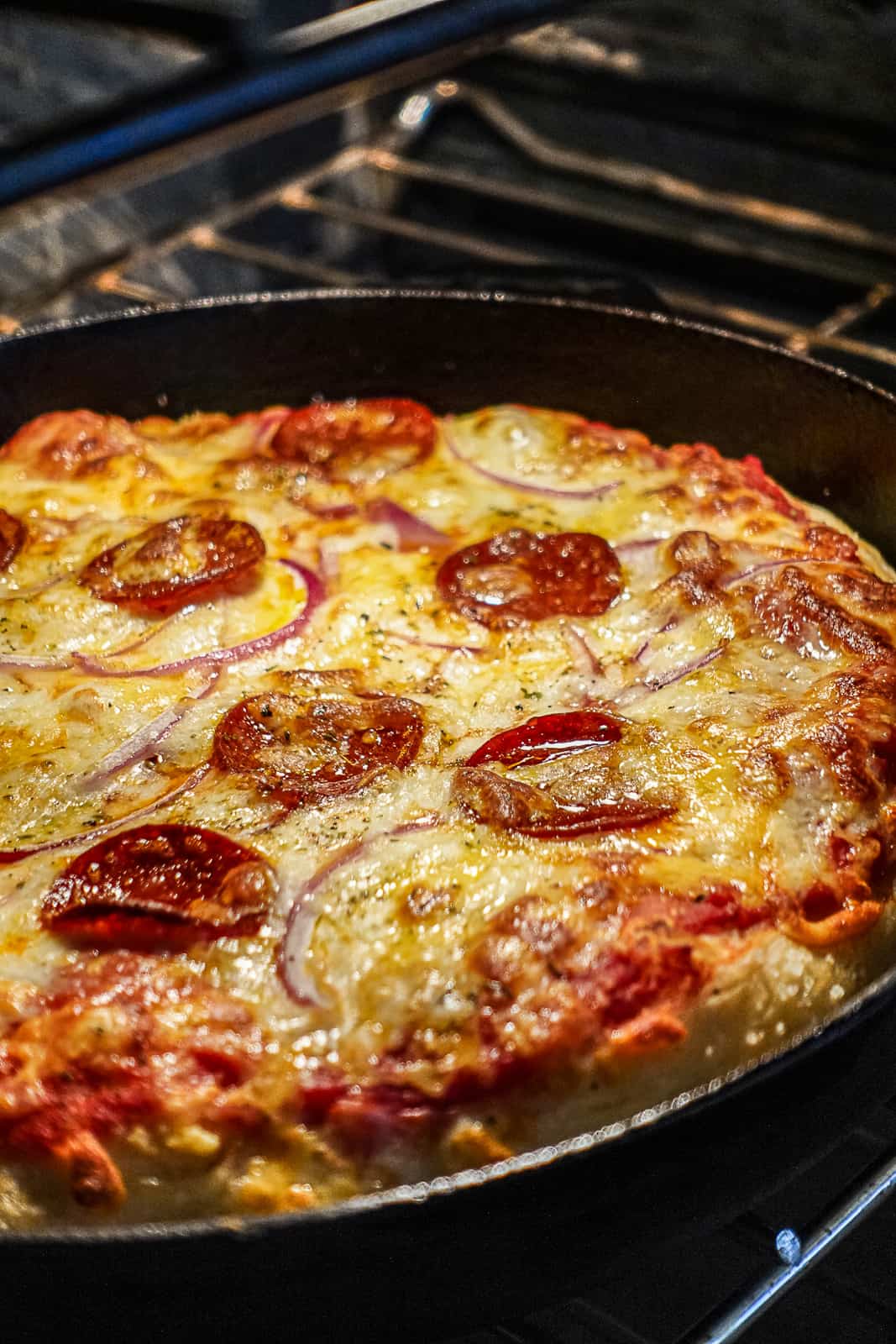 Pepperoni Pizza Baking in a Cast Iron Skillet In The Oven