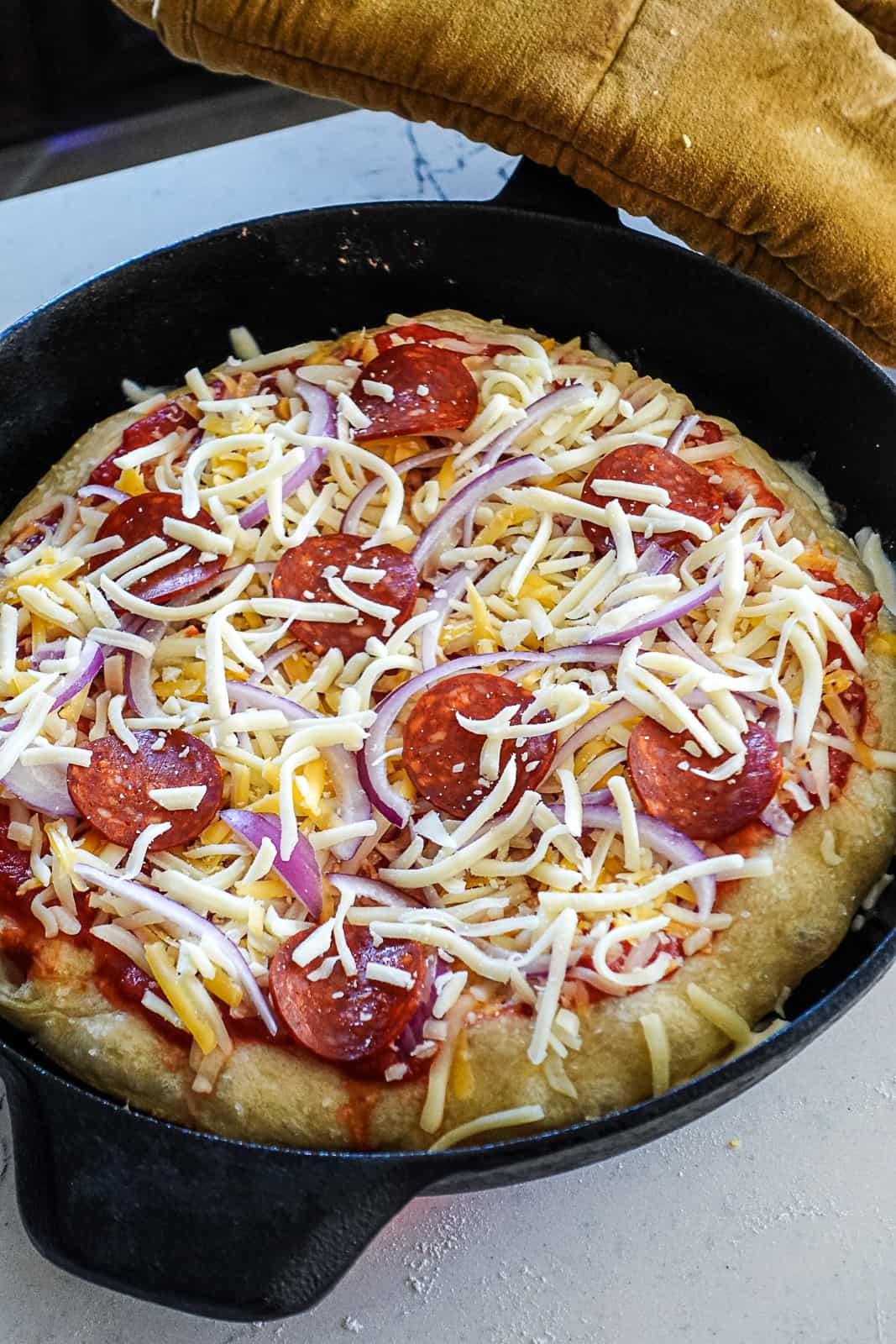 Raw Pizza Toppings on Cast Iron Cooked Pizza Dough