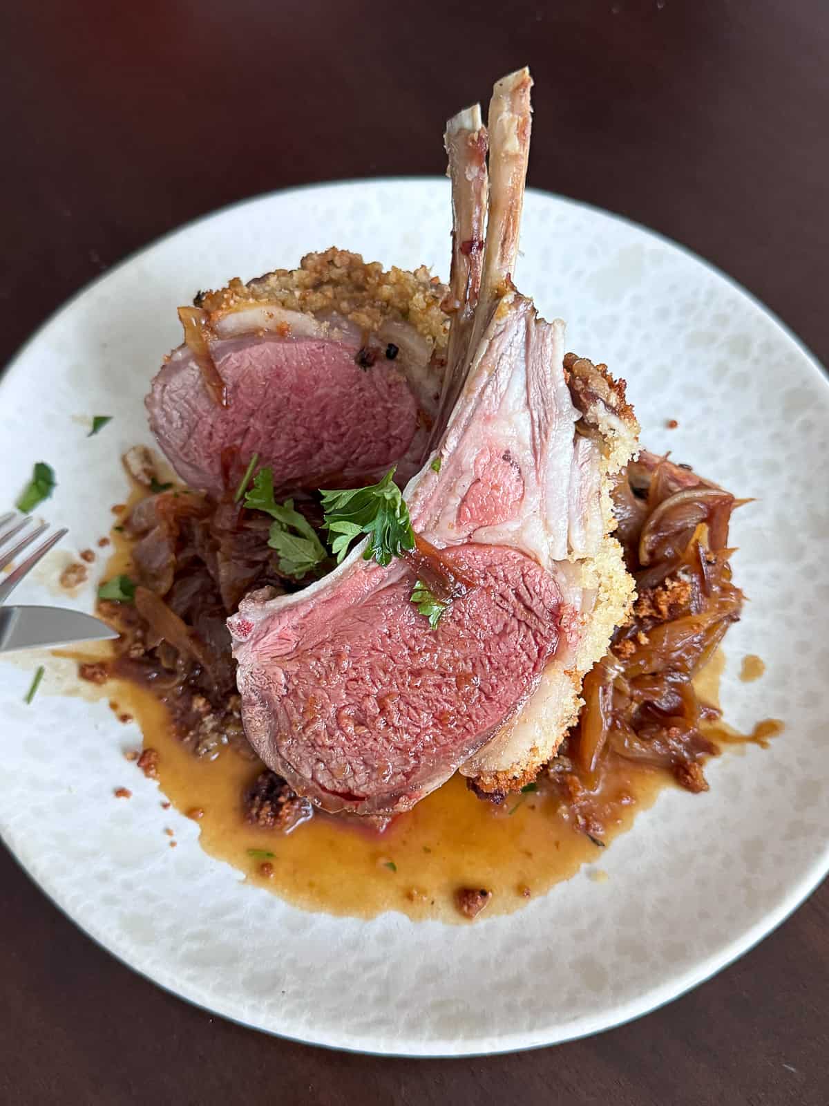 Closeup of dinner plate with Baked Rack of Lamb and sauce
