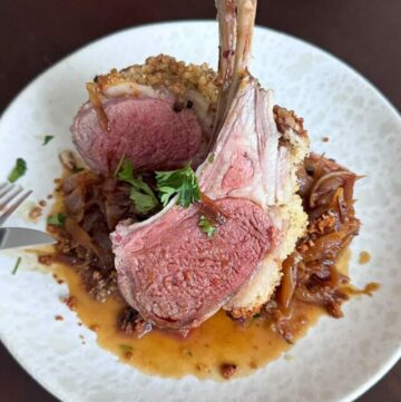 Closeup of dinner plate with Baked Rack of Lamb and sauce